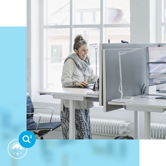 Schulterblick Unsere Kollegin Johanna an ihrem Schreibtisch.