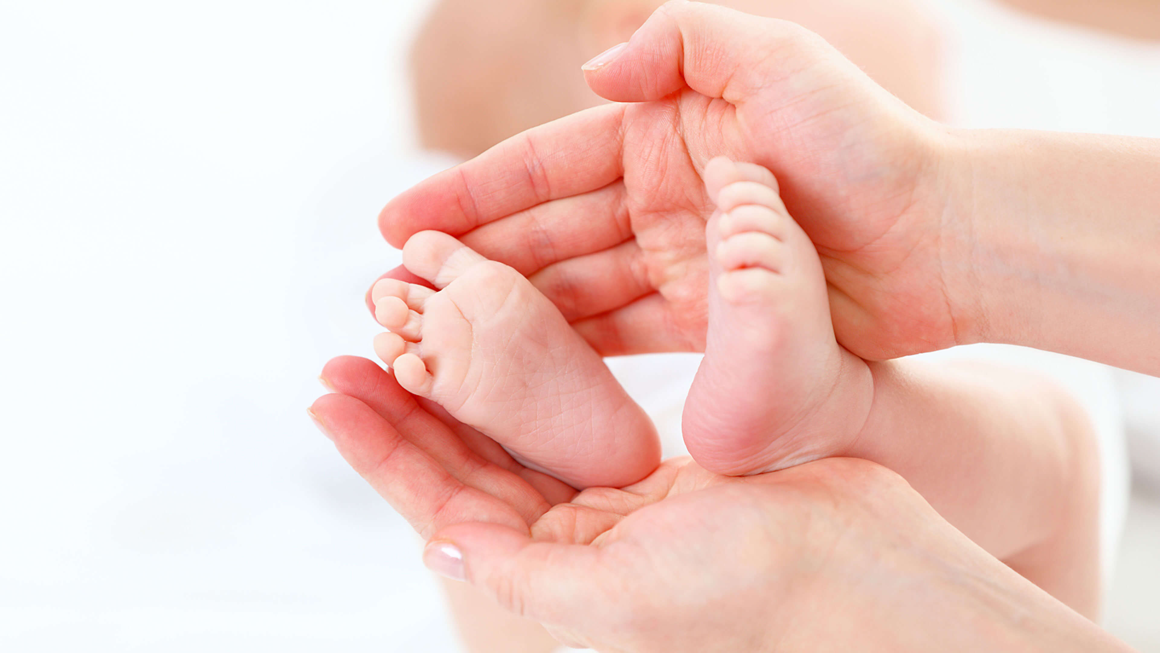 Hand hält Babyfüße