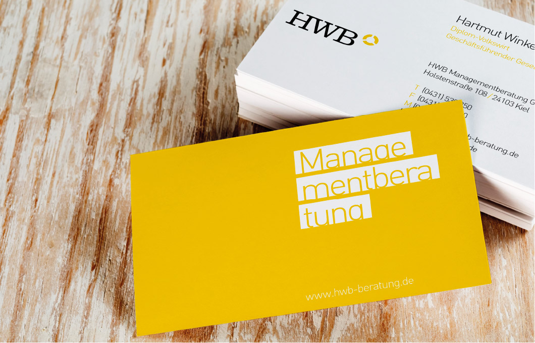 Gelbe Visitenkarte von hwb auf Holztisch