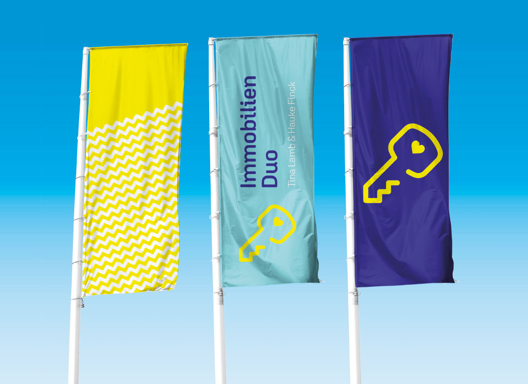 immobilien-duo-11.jpg Drei Fahnenmaste mit bunten Flaggen von Immobilien Duo