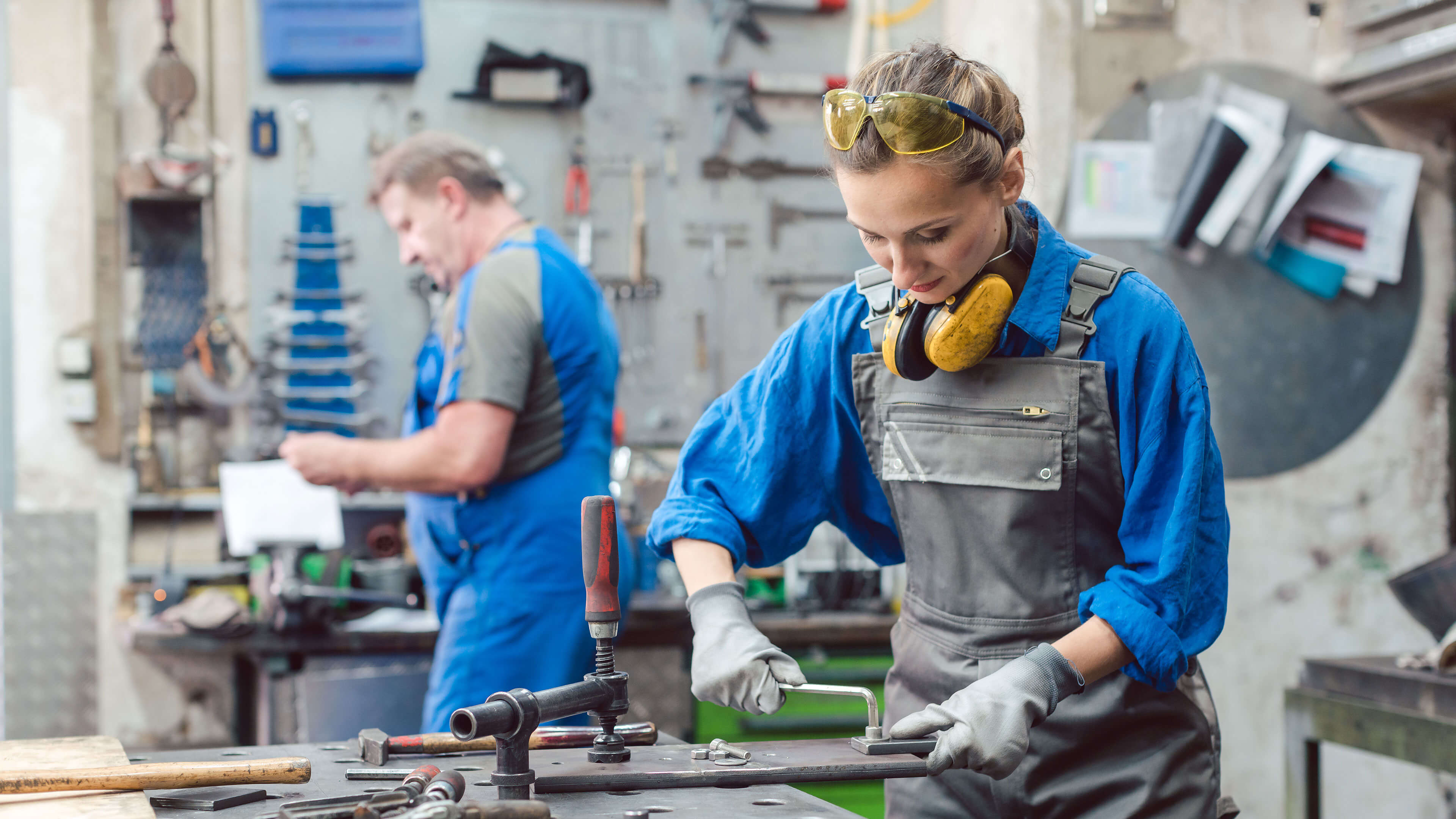 Zwei Personen bei der Arbeit in einer Werkstatt