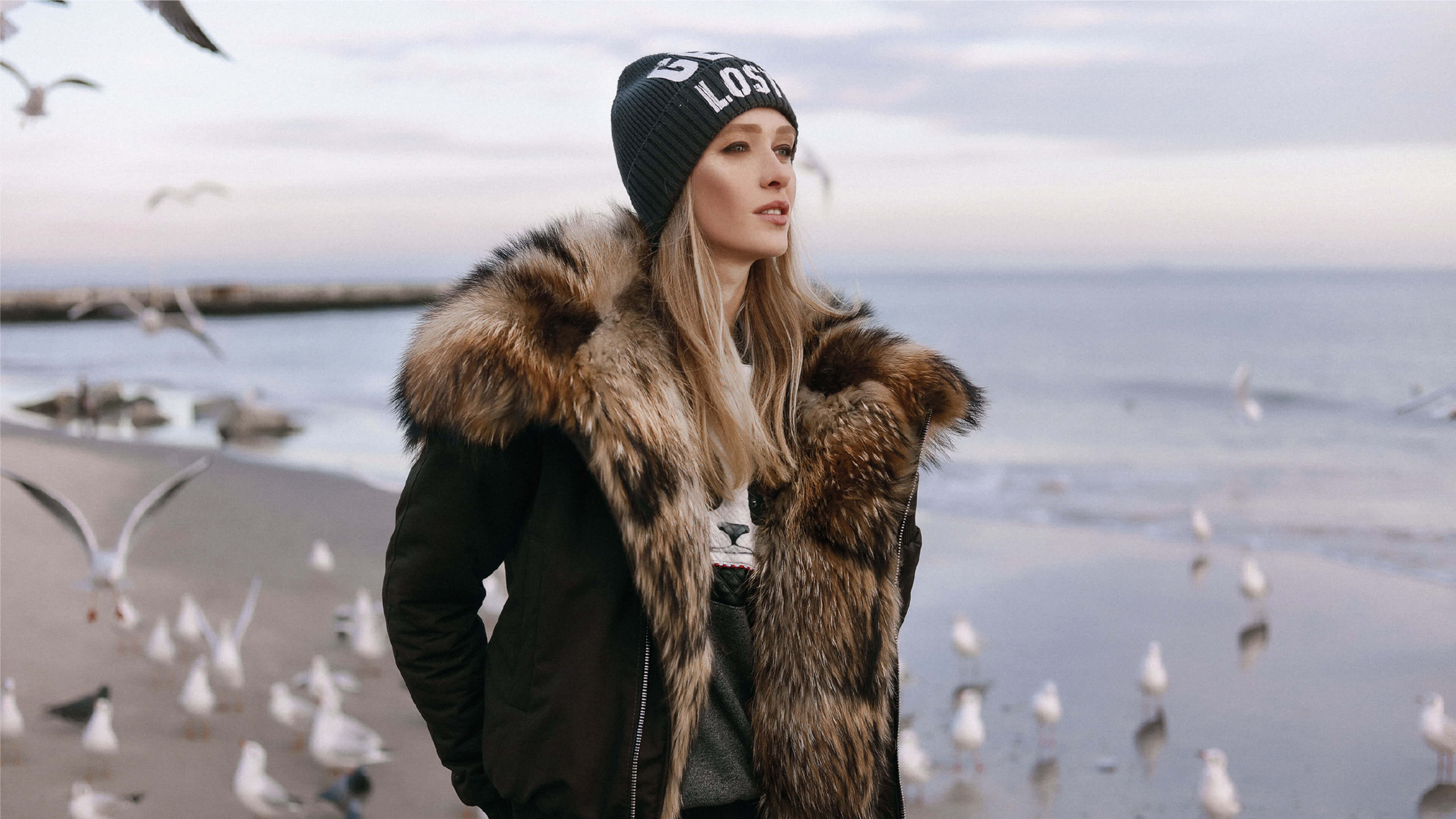 Frau in Pelz am Strand