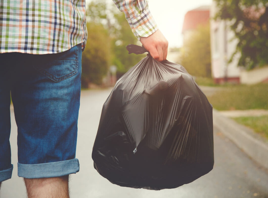 remondis-07.jpg Mann trägt Müllbeutel