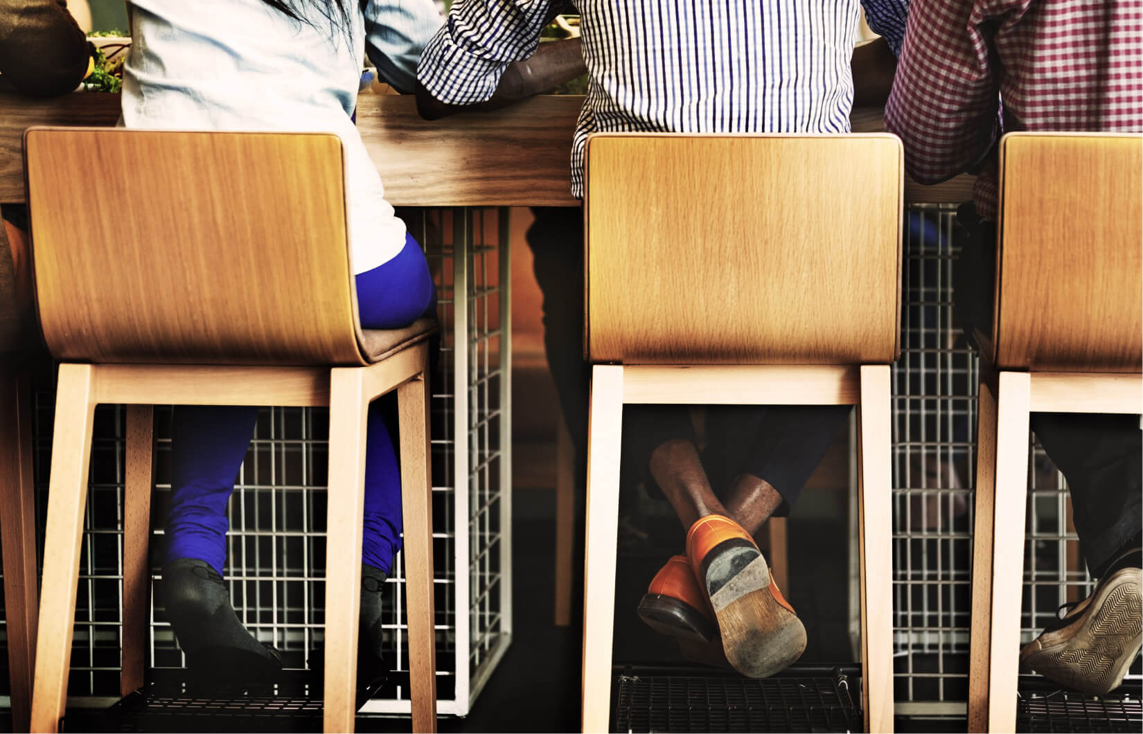 Drei Personen sitzen auf Barhocker