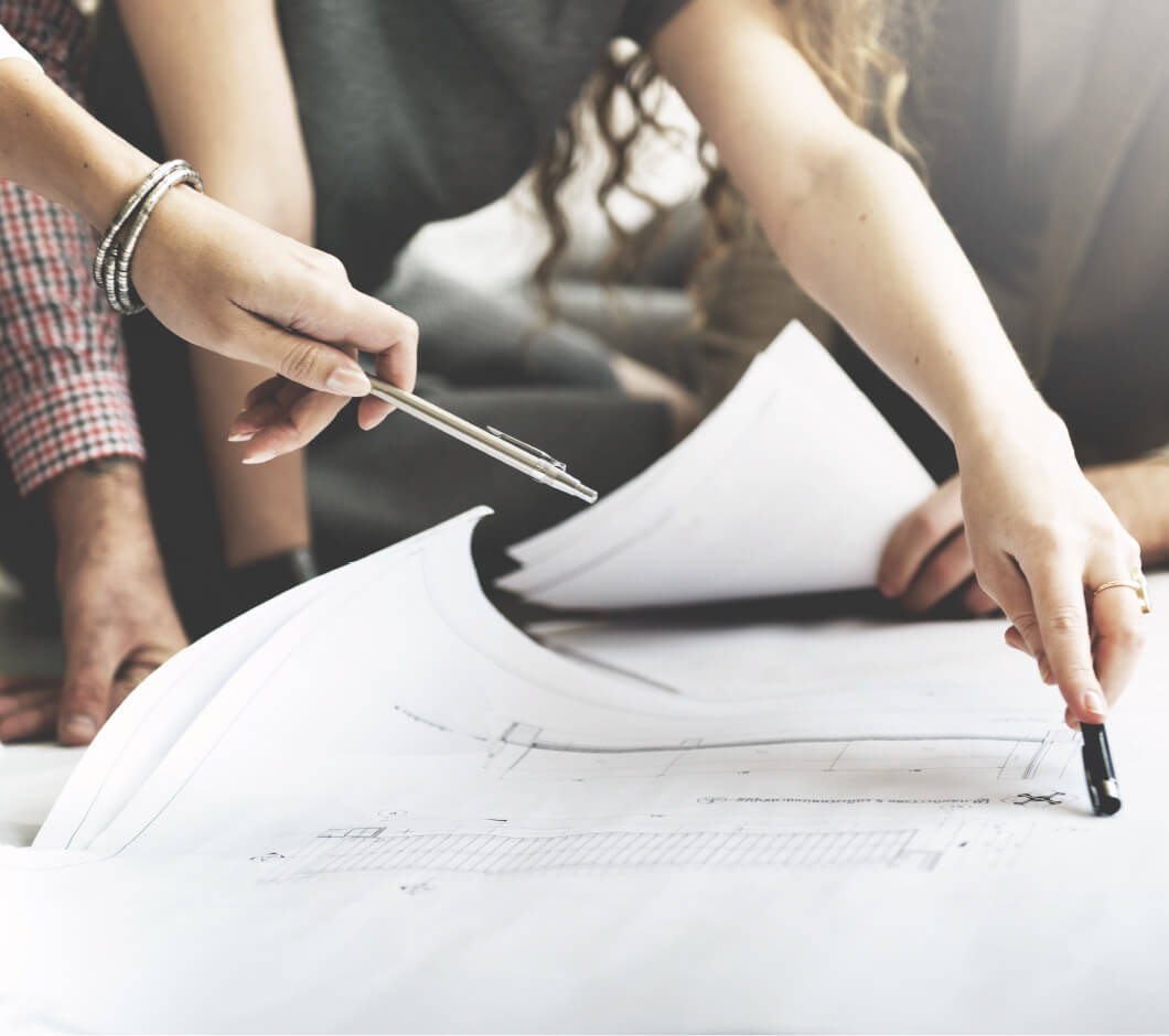 Mehrere Hände zeigen auf Papier