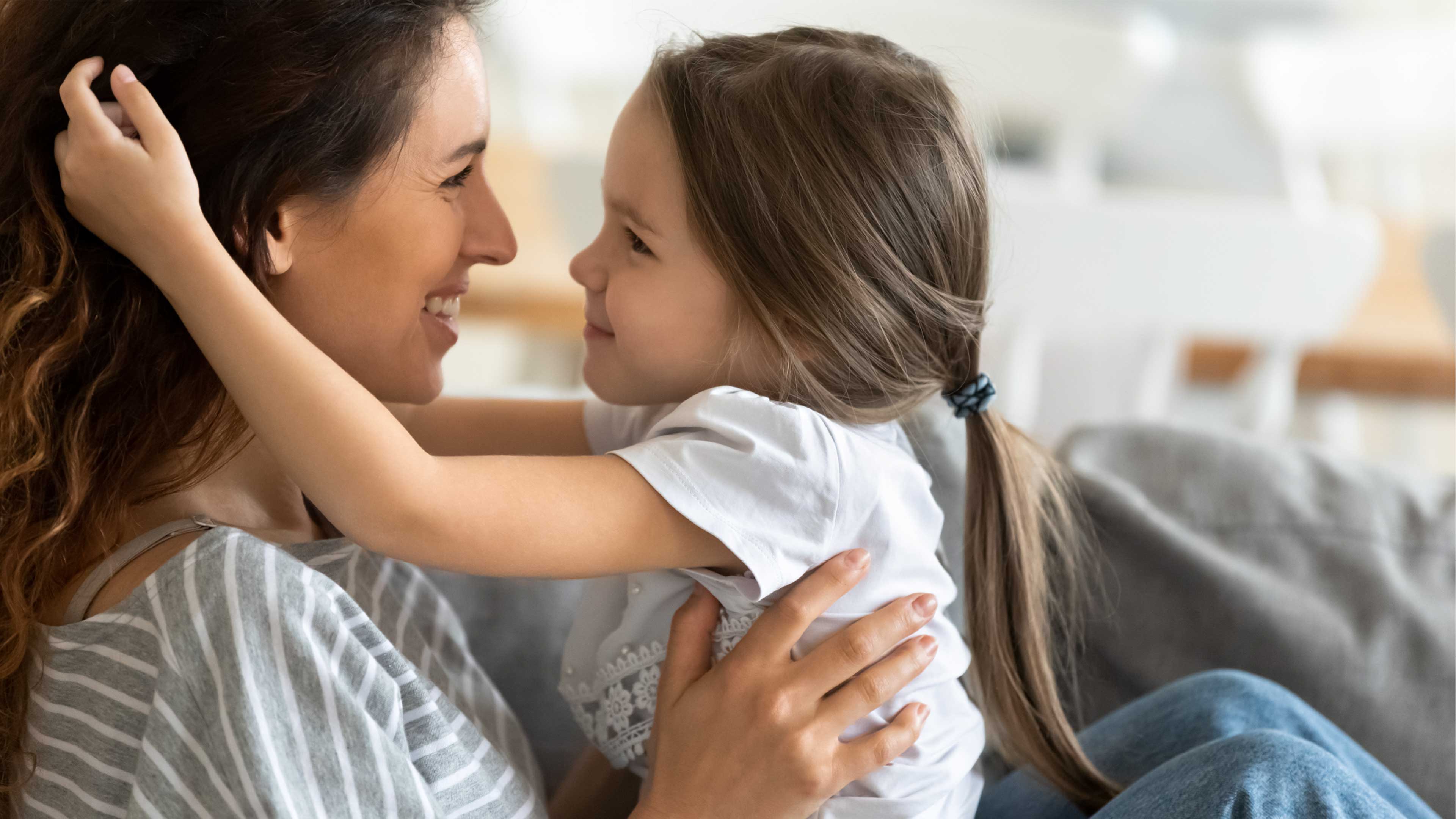 Braunhaarige Mutter umarmt Tochter