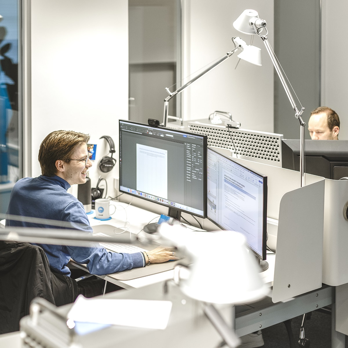 Team Grafik sitzt an ihren Schreibtischen