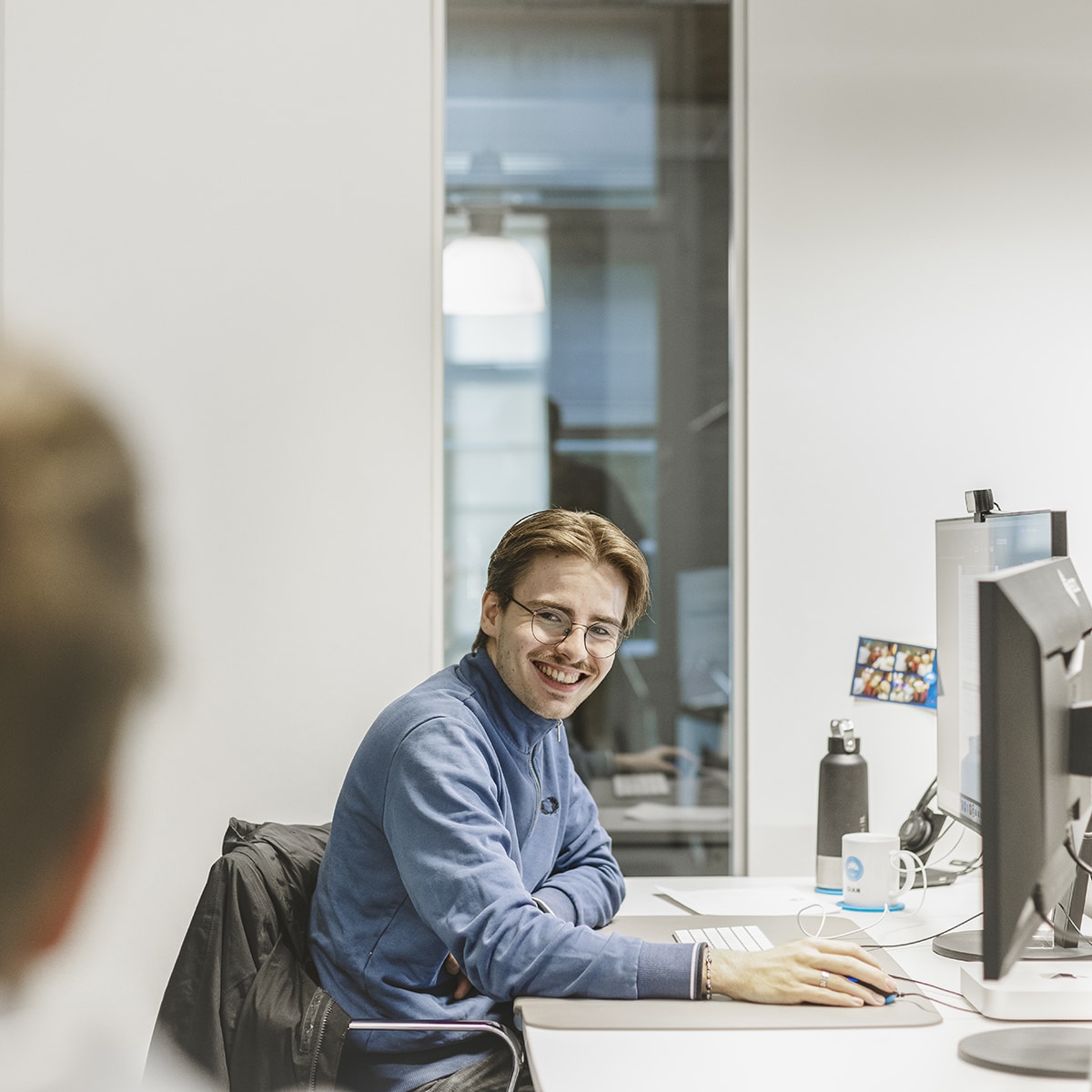 Mitarbeiter von HOCHZWEI lächelt und blickt Kollegen an