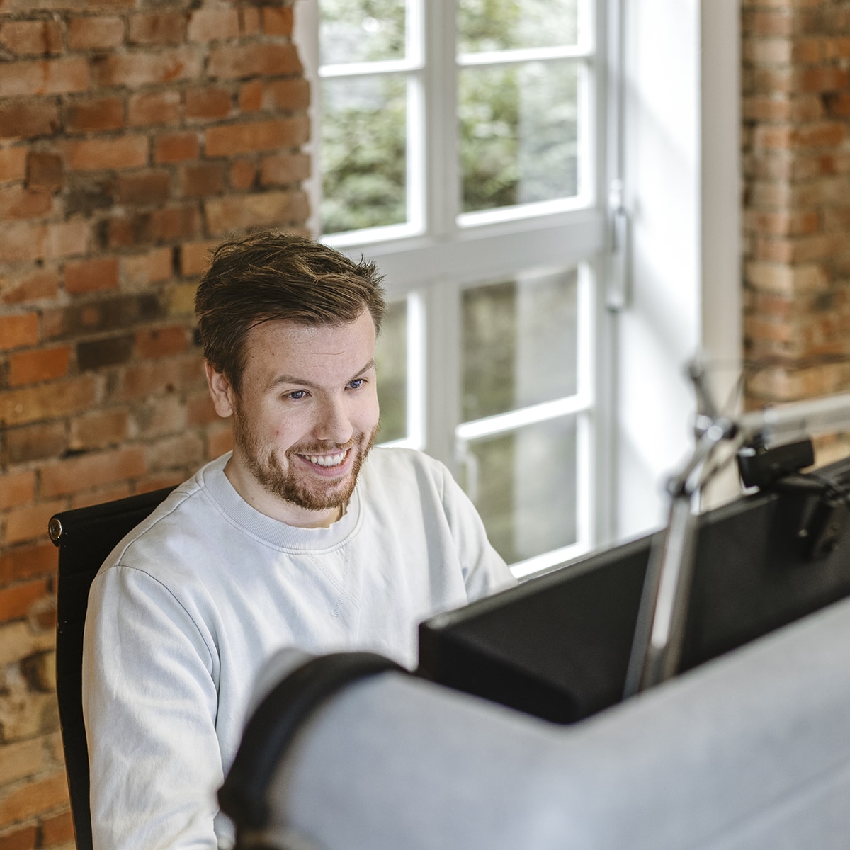 hochzwei-mitarbeitermotiv_M9A2265.jpg Blick über den Sichtschutz auf einen Mitarbeiter von HOCHZWEI