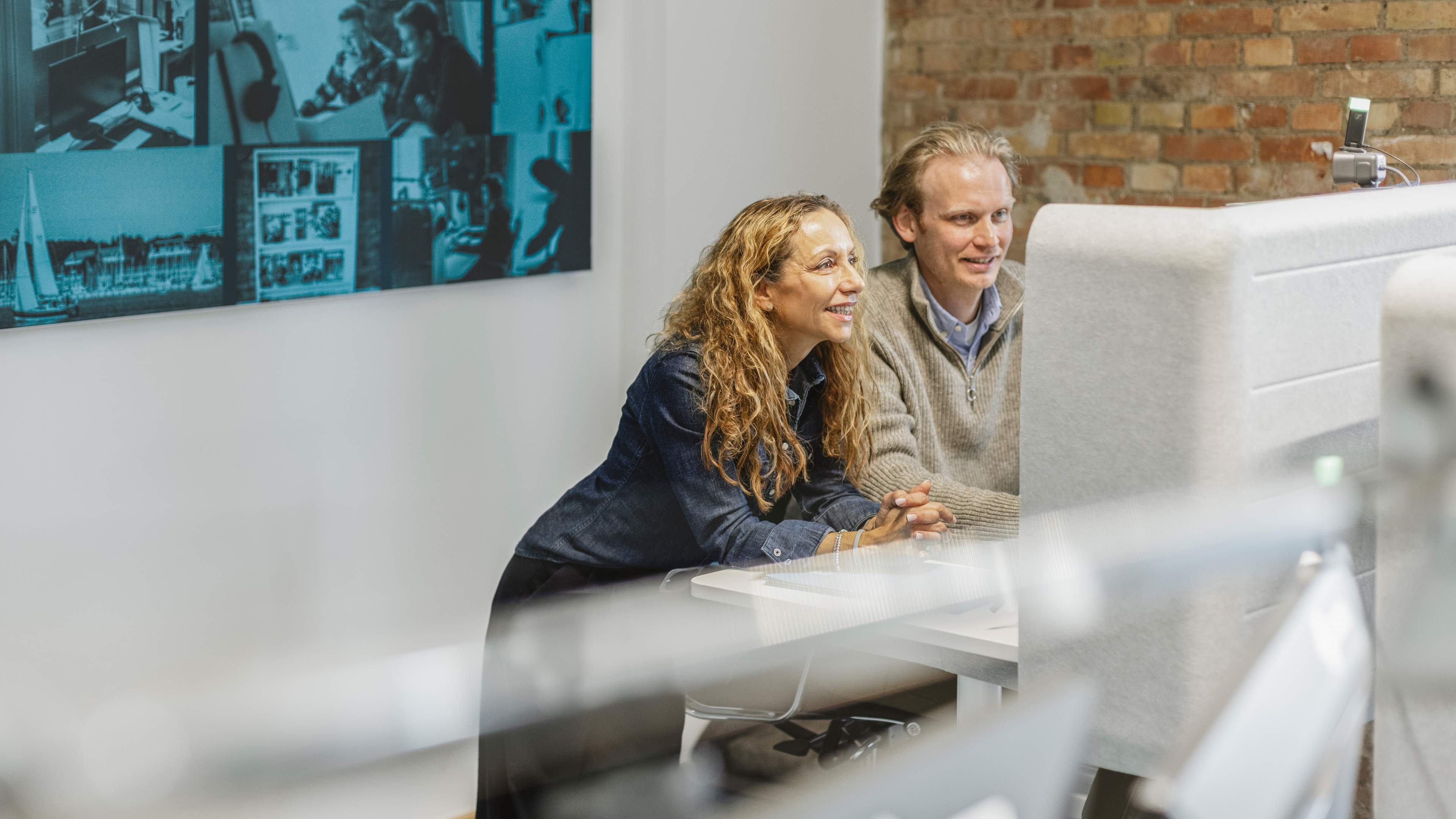 Zwei HOCHZWEI Mitarbeiter stehen vor einem Schreibtisch