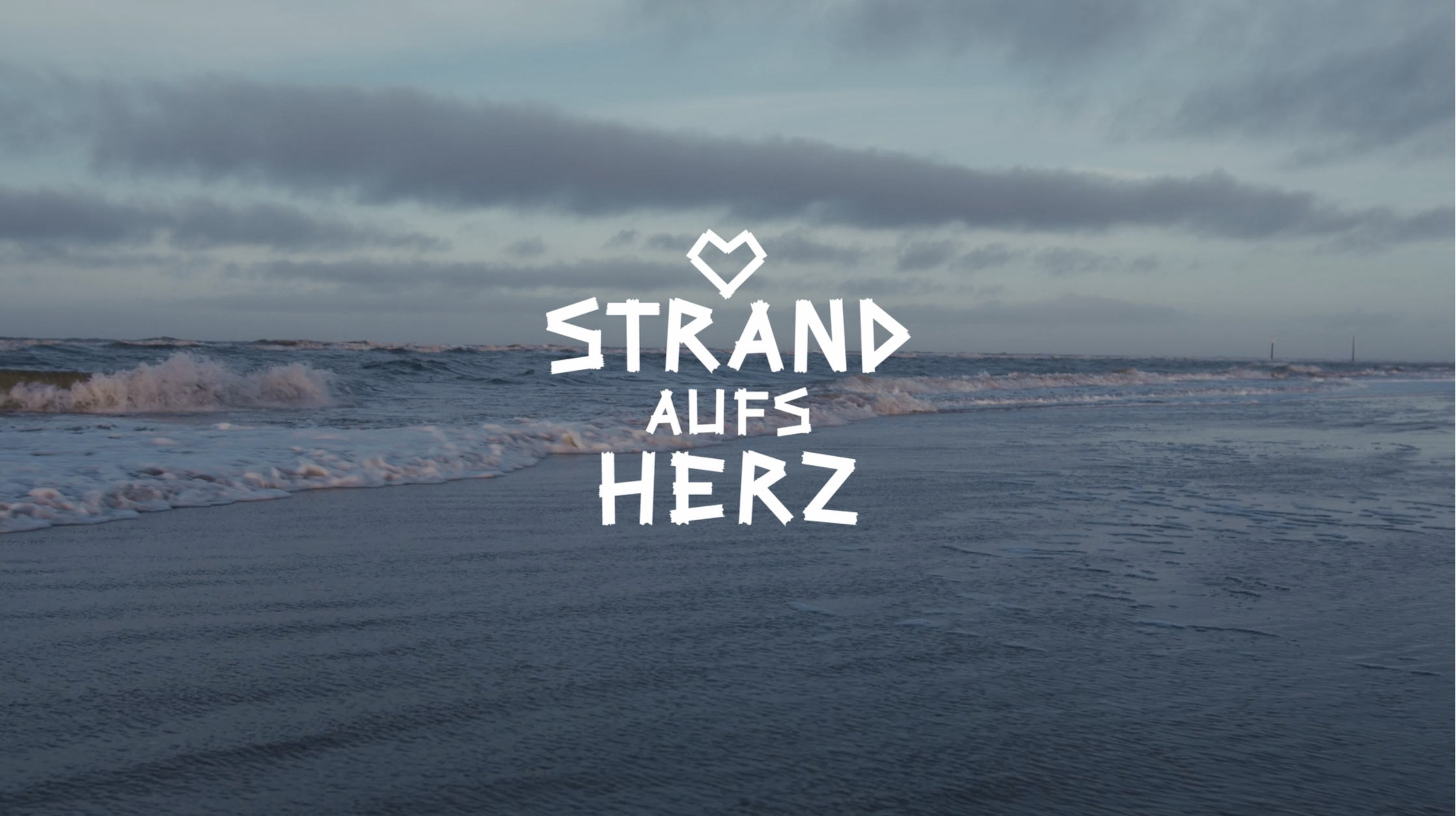 Foto von der Brandung und der Schriftzug Strand aufs Herz