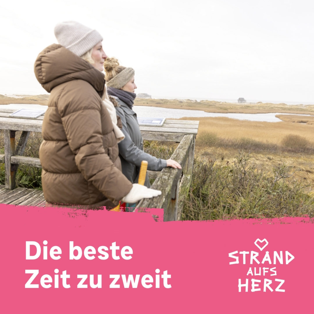 Zwei Frauen auf einer Aussichtsplattform am Strand