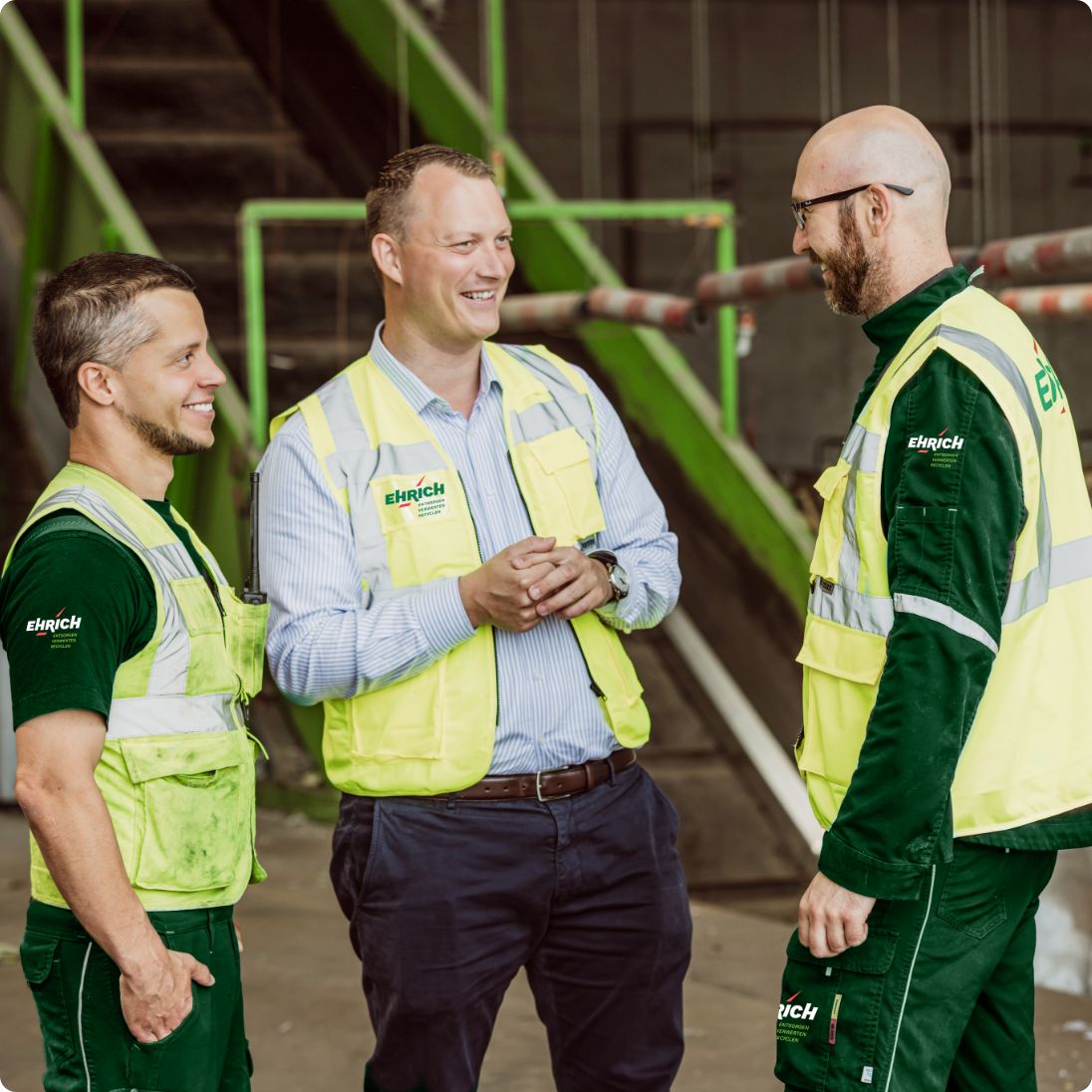 Drei Ehrich Mitarbeiter unterhalten sich auf dem Platz