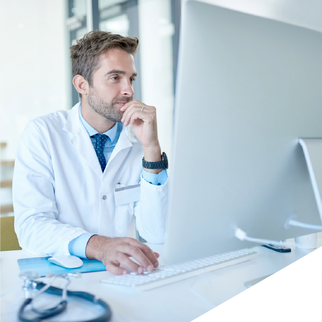 Ein junger Arzt an einem Schreibtisch.