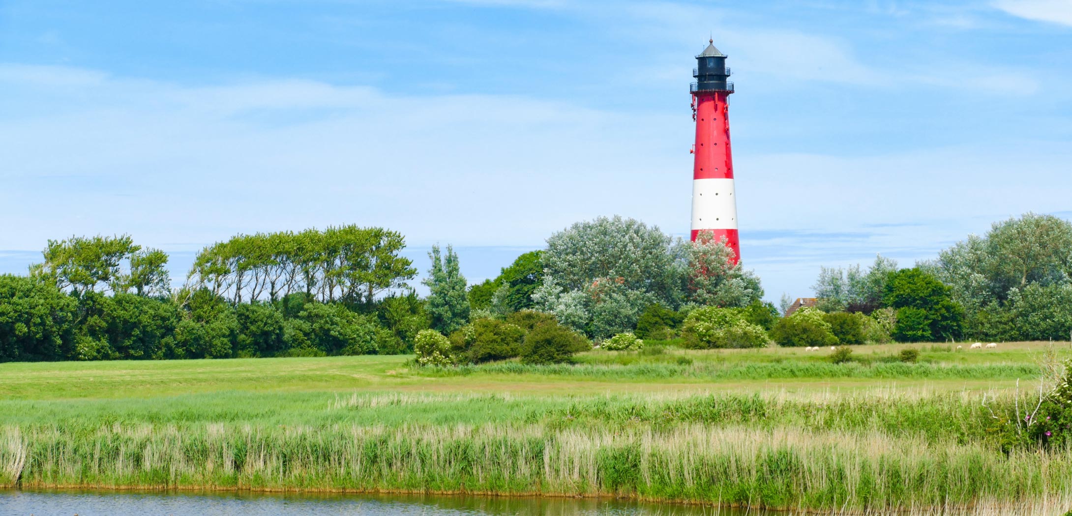 Foto des Leuchtturms bei Sonnenschein und blauem Himmel