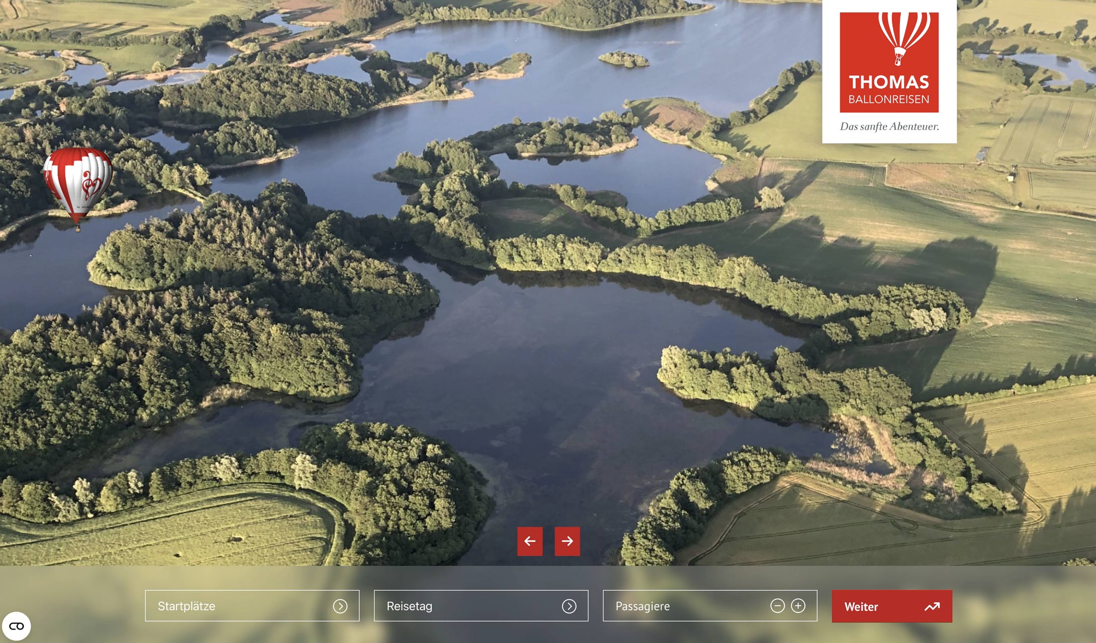 Luftaufnahme einer Seenlandschaft mit einem Heißluftballon