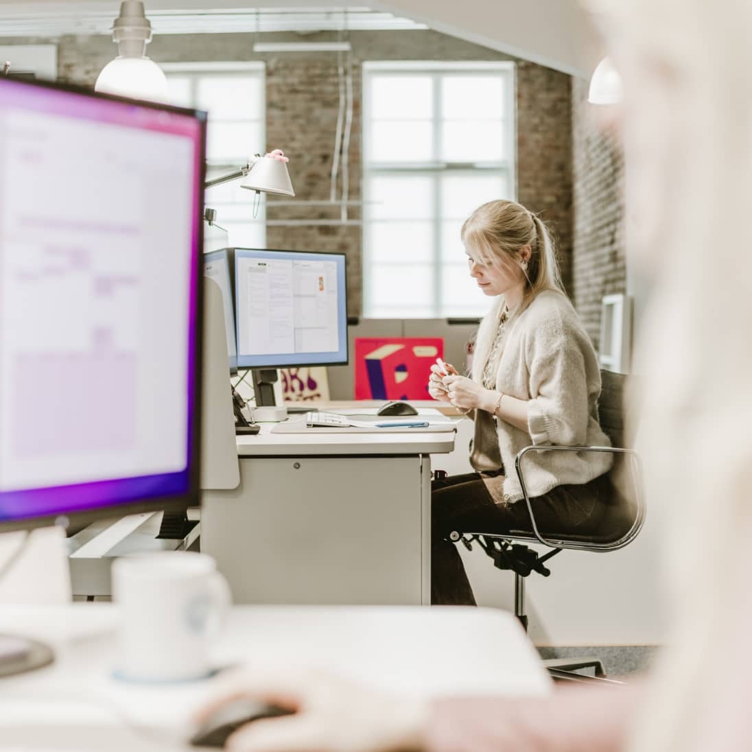 Foto unserer Kollegin bei der Arbeit an ihrem Schreibtisch