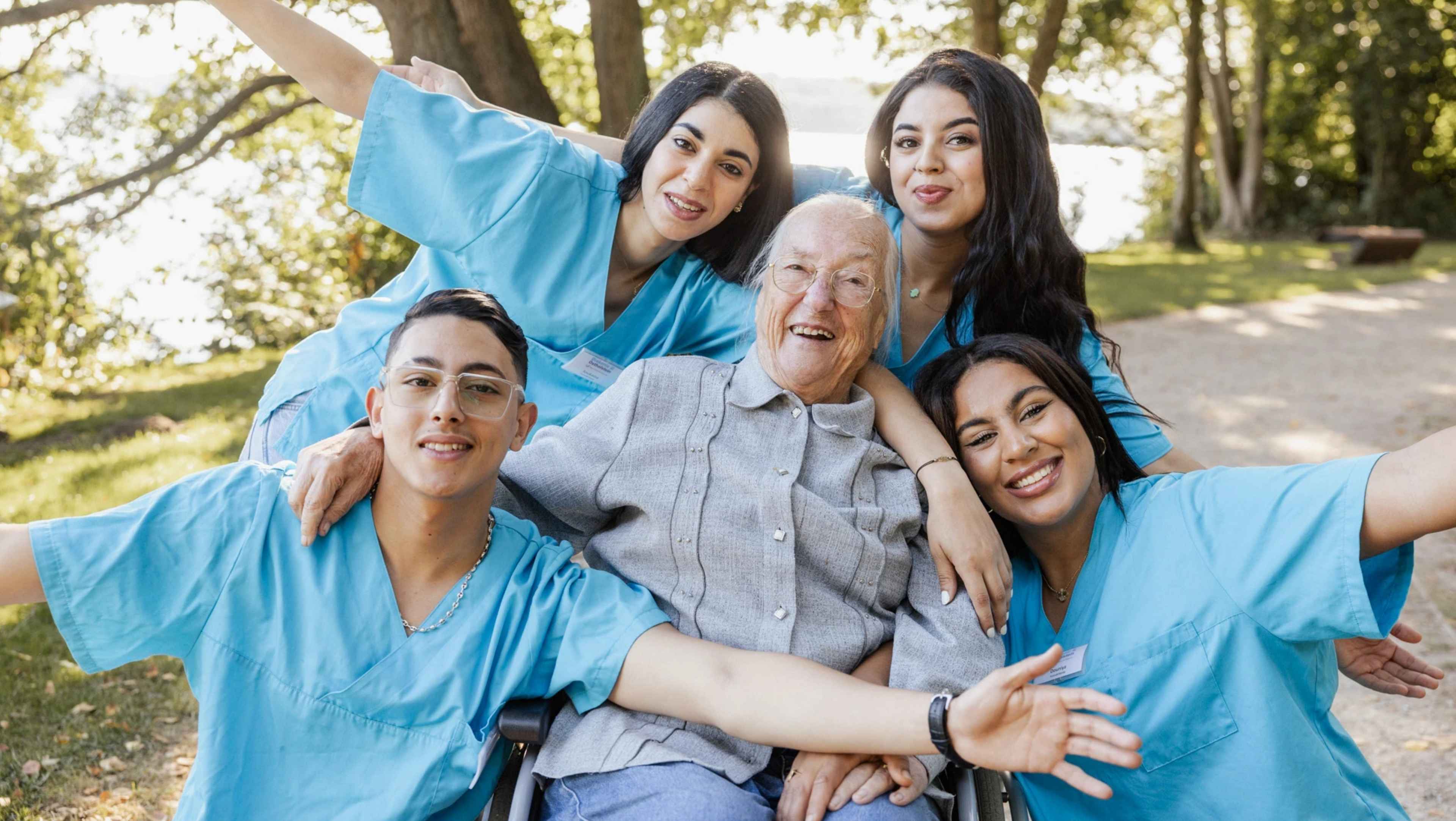 Foto von vier Angestellten mit einer Patientin auf einem Waldweg an einem See