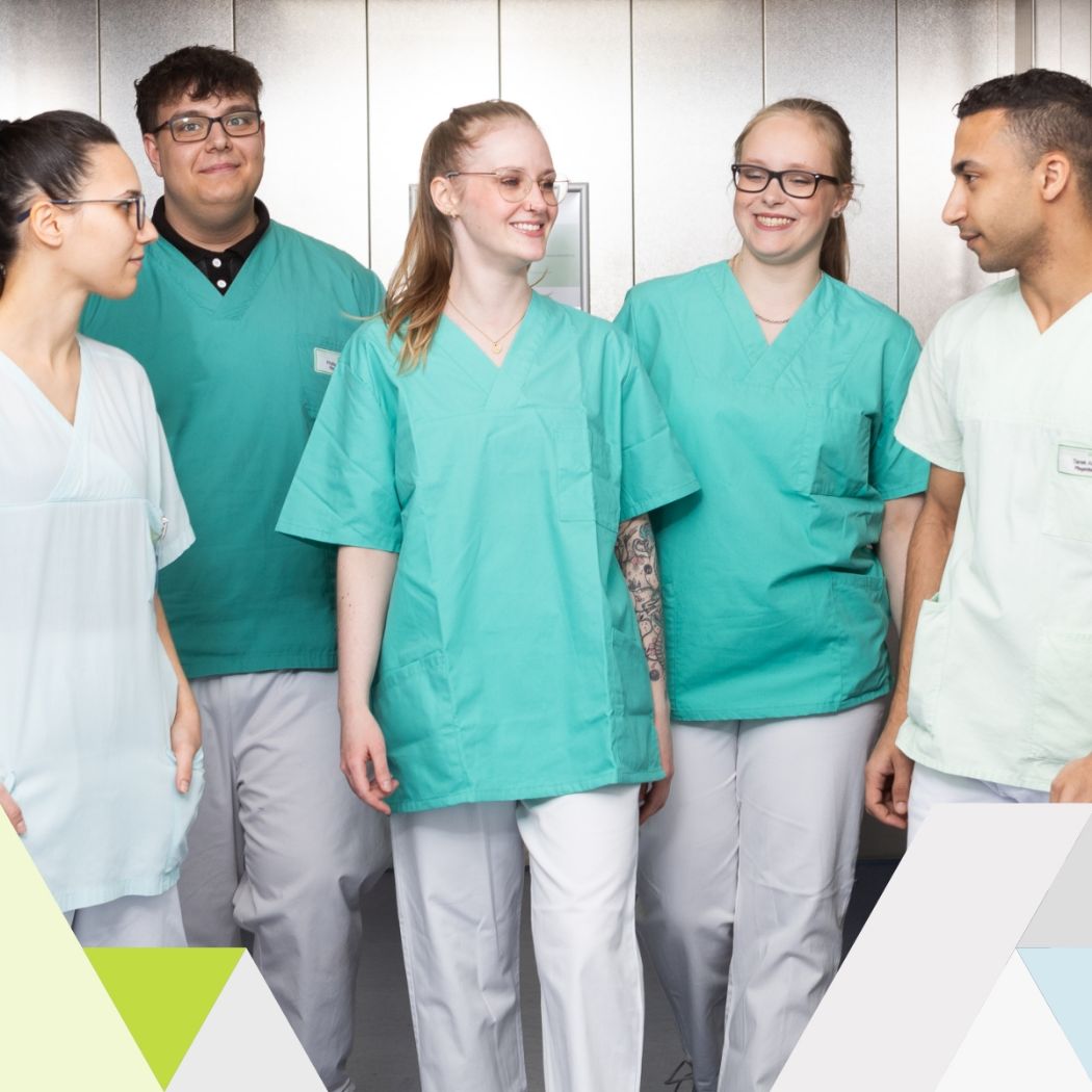 Teamfoto mit fünf Pflegekräften in Arbeitskleidung