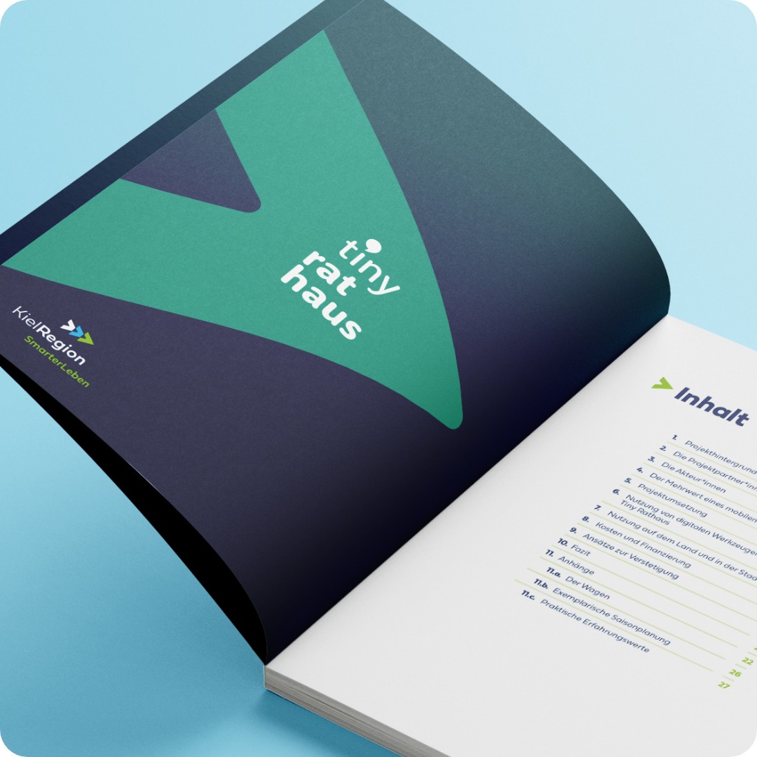 Ein aufgeschlagenes Handbuch mit einer dekorierten einleitenden Seite mit dem Titel tiny rathaus. Auf der nächsten Seite sieht man das Inhaltsverzeichnis.