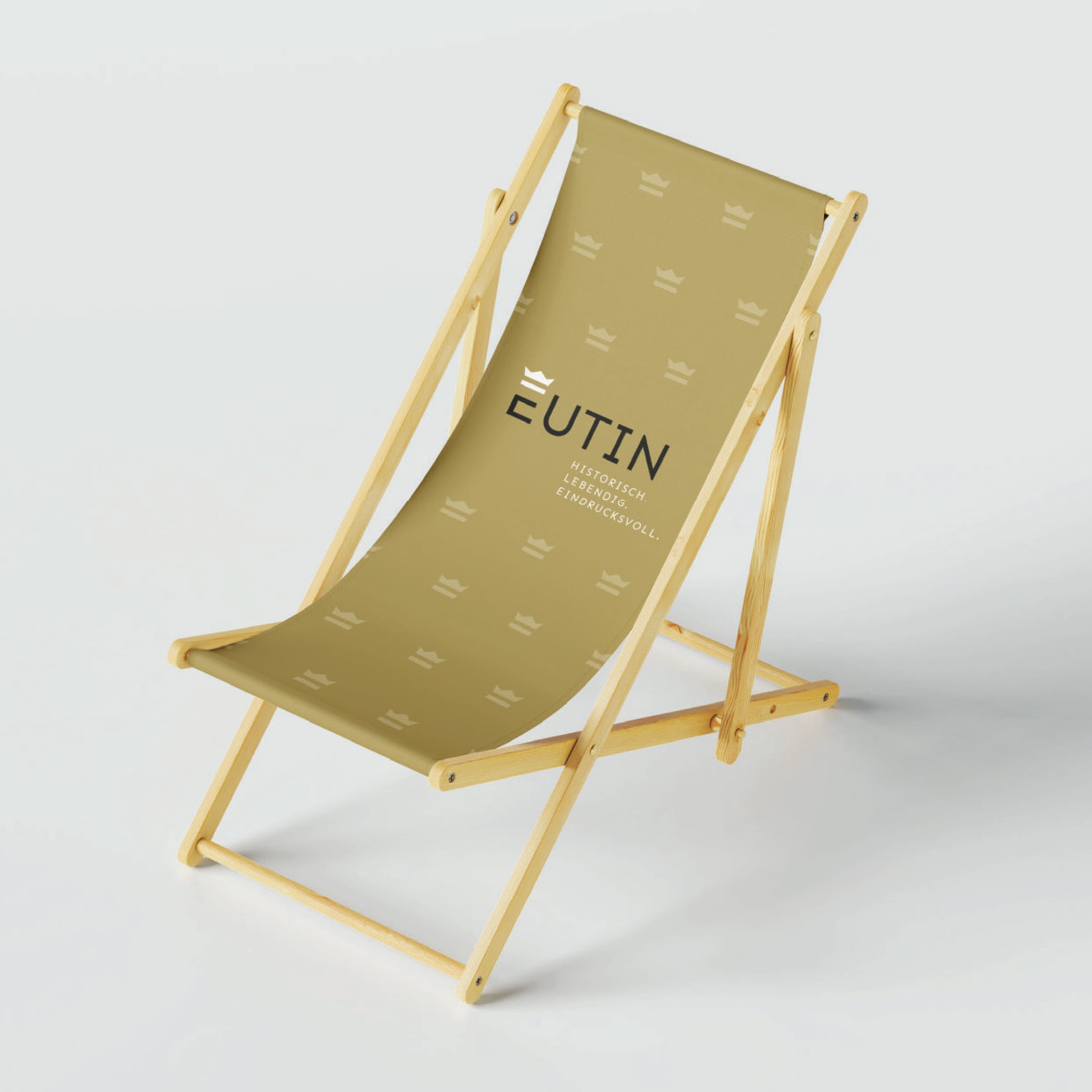 Klappstuhl mit goldener Sitzfläche und Eutin-Logo mit Krone