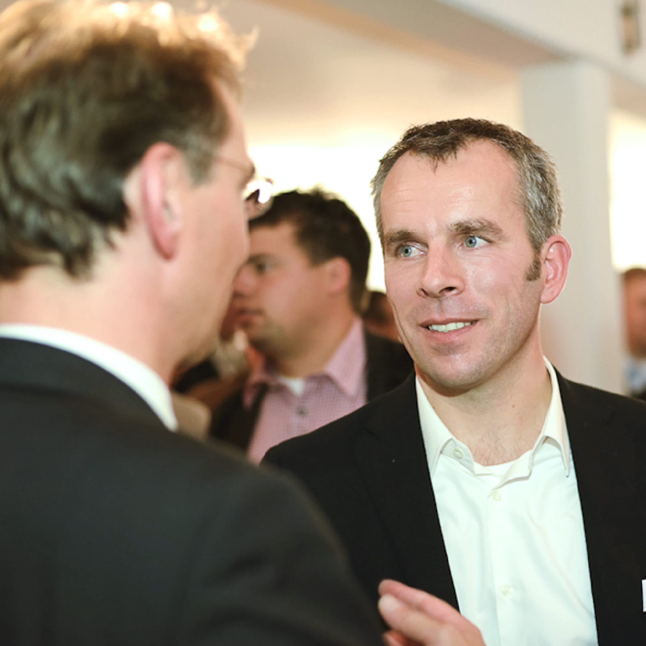 hochzwei_gp_teaser_05.jpg Zwei Männer im Anzug unterhalten sich