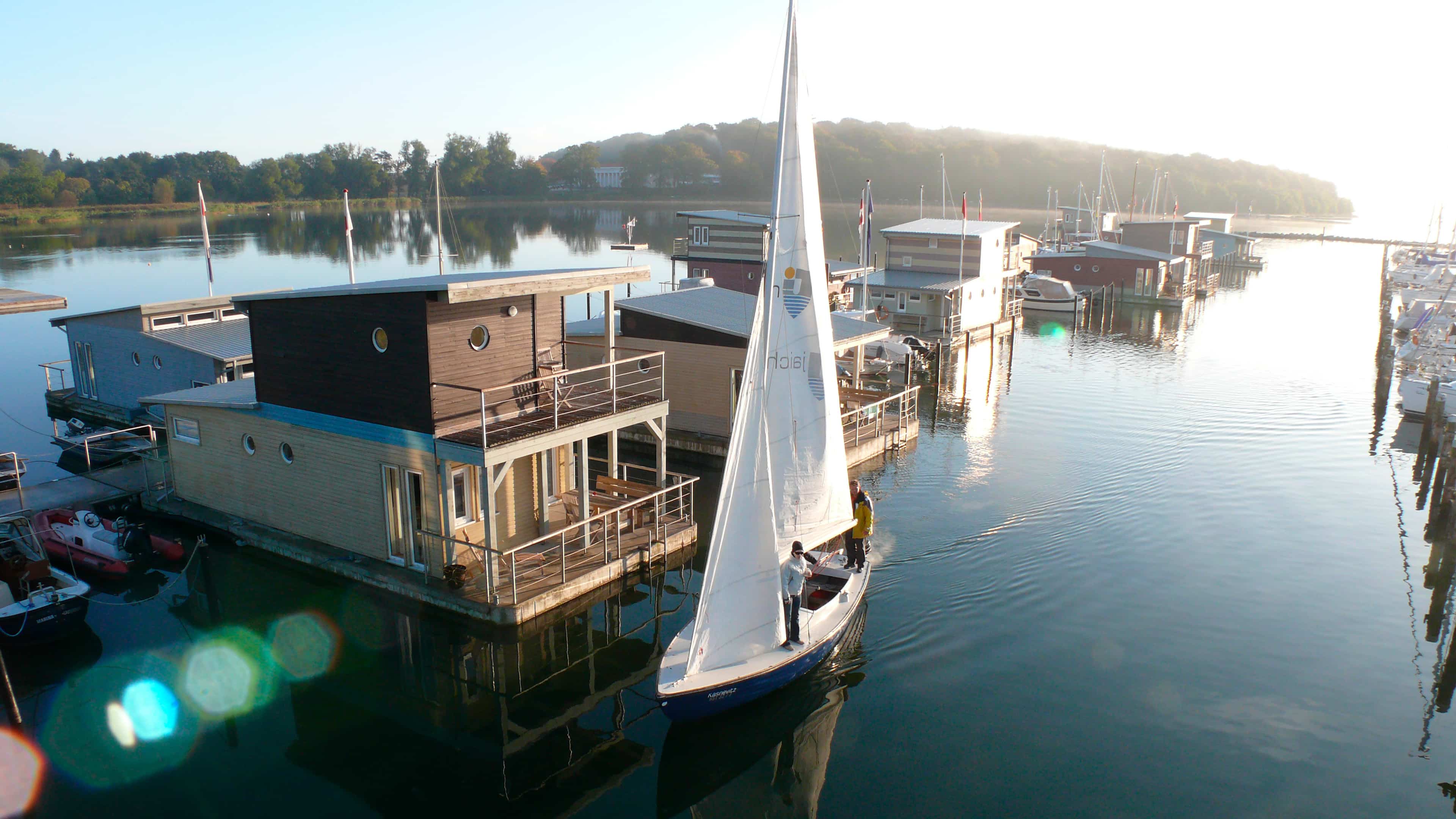 hochzwei_imjaich_slider_02.jpg Ein Segelboot hält vor einem Hausboot