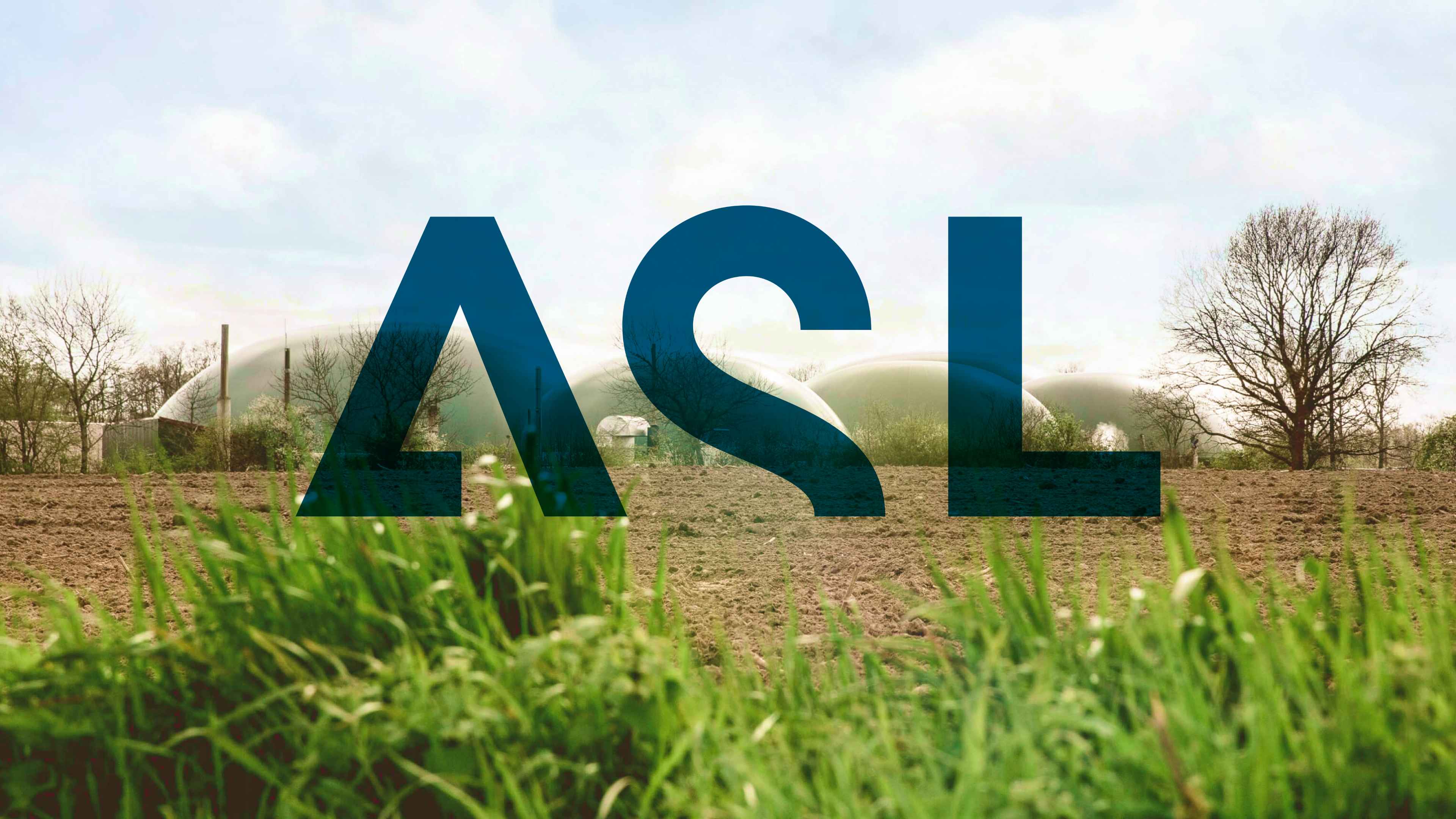 Die Buchstaben A S L in dunkelblau groß in ein Foto einer Feldlandschaft eingebaut