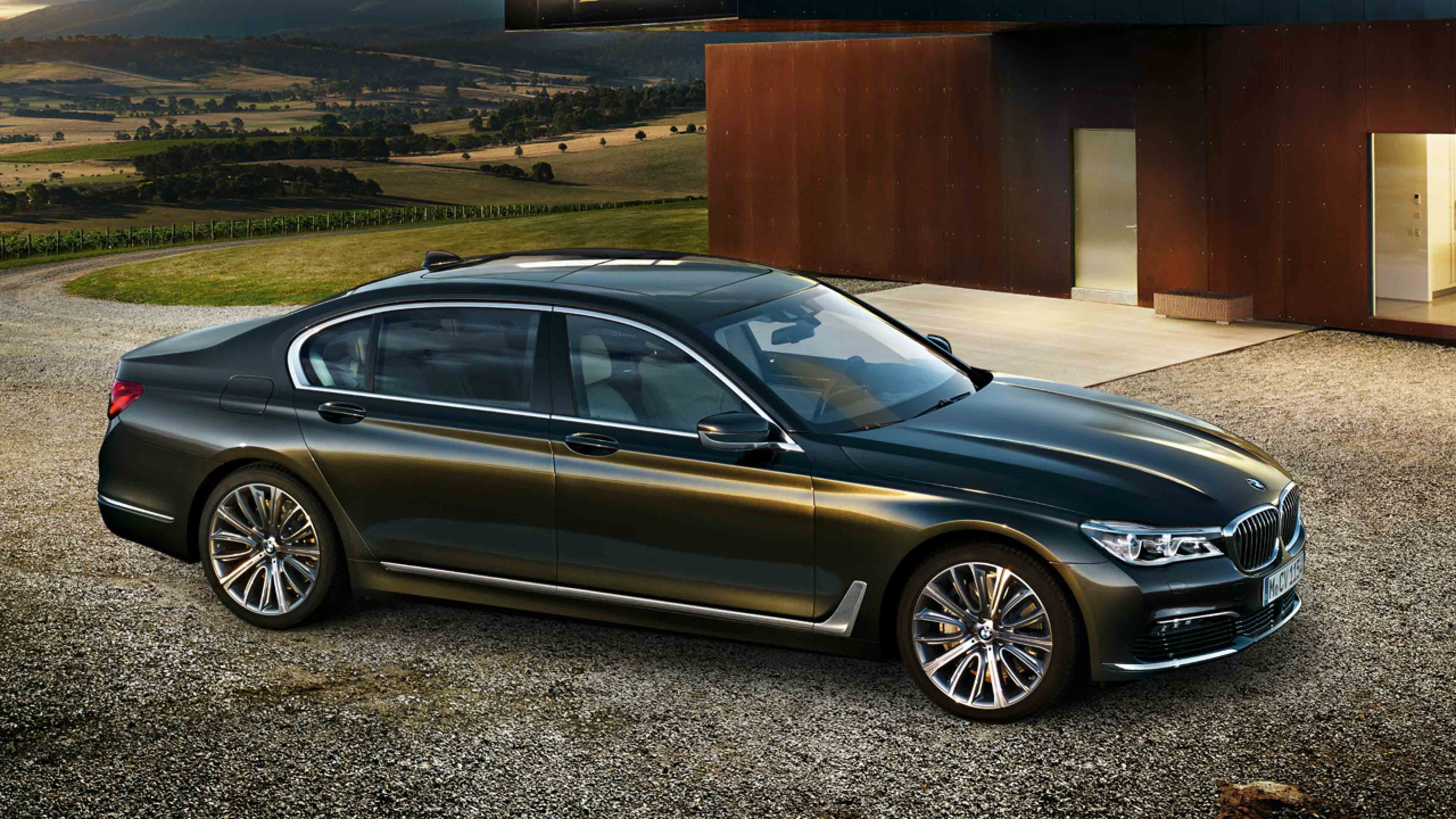 Schwarzer BMW 7er steht auf Kies