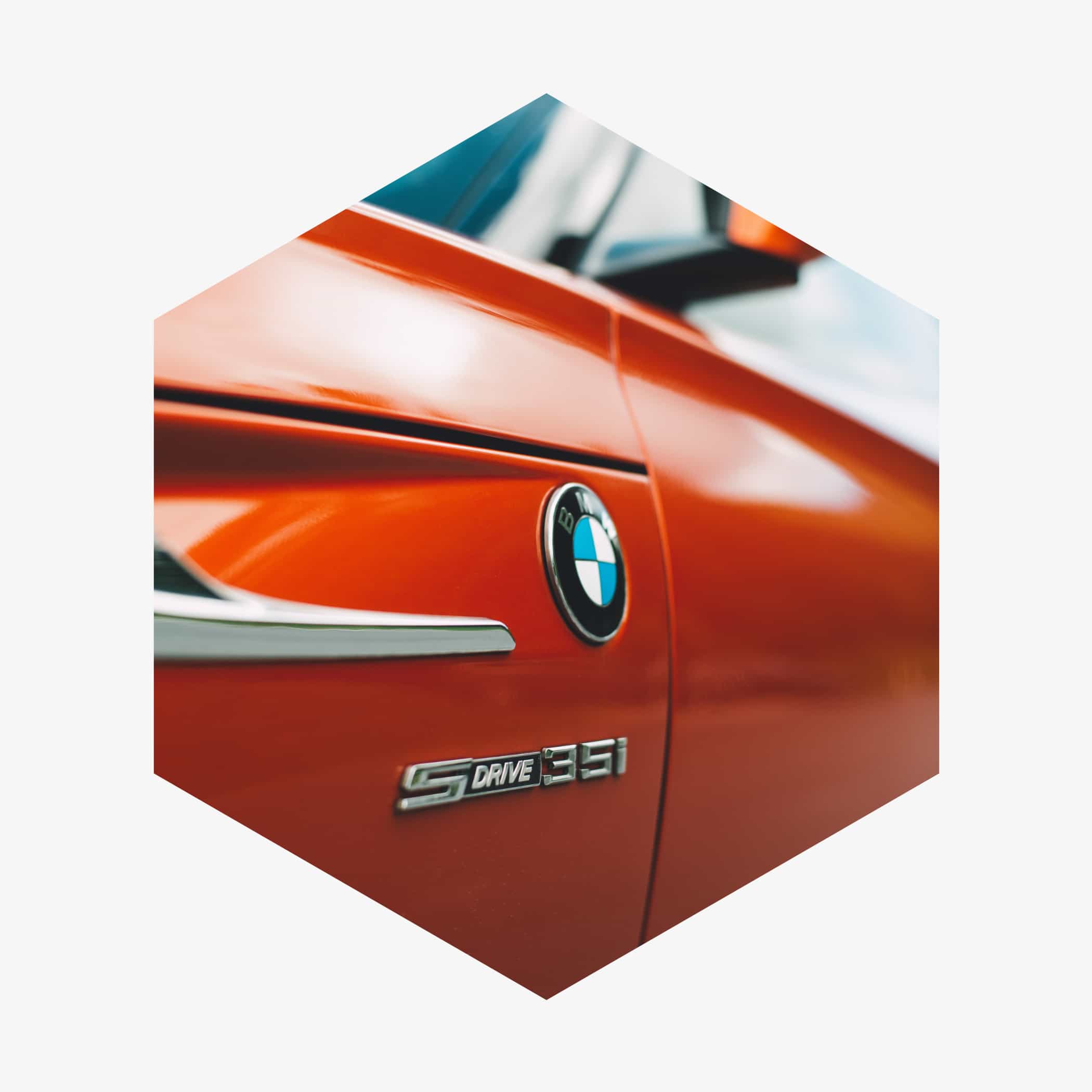 hochzwei_backp_teaser_03.jpg Sechseckige Nahaufnahme eines roten Autos mit BMW-Emblem
