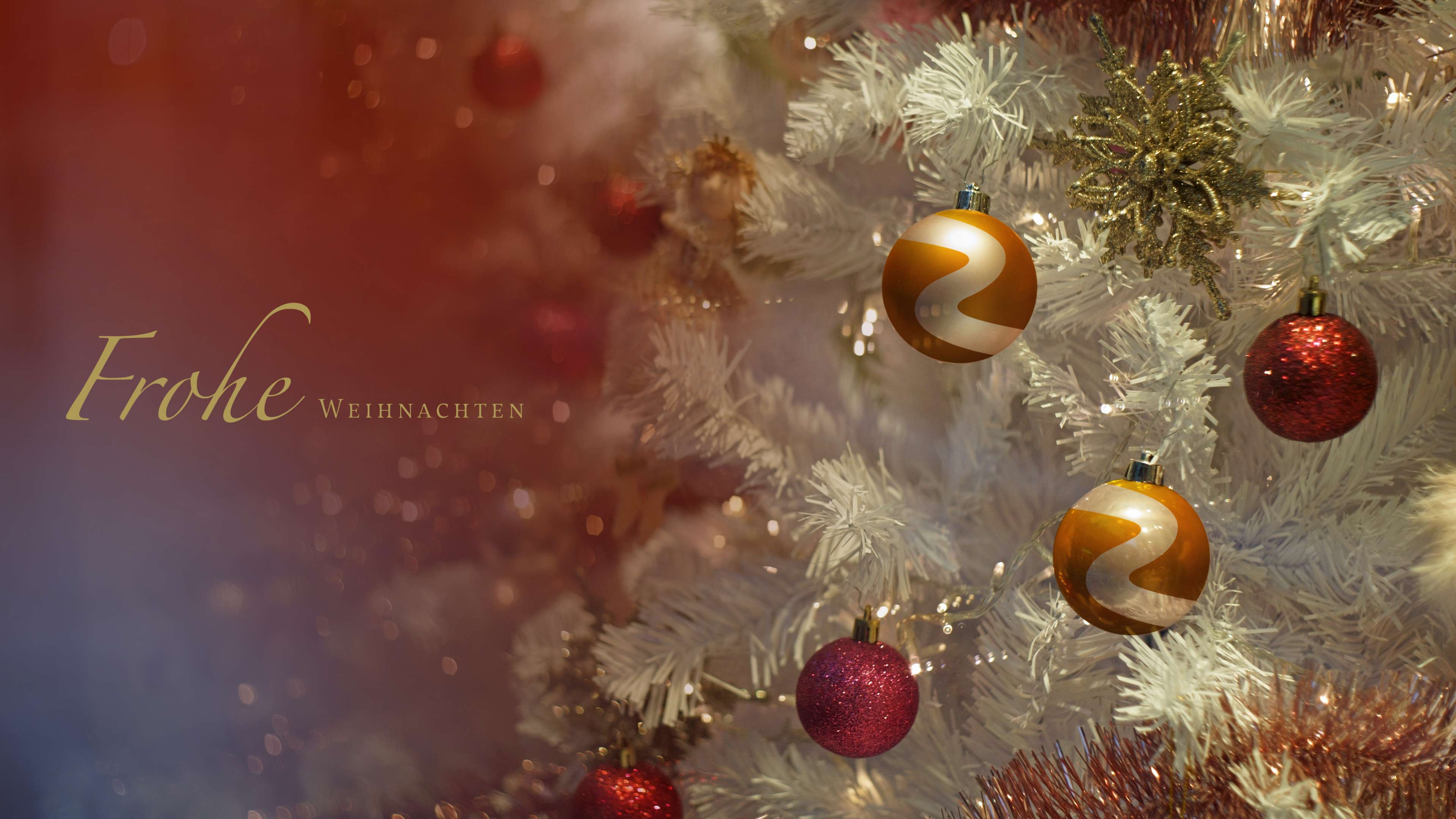 Orangene und rote Weihnachtskugeln in einem weißen Weihnachtsbaum