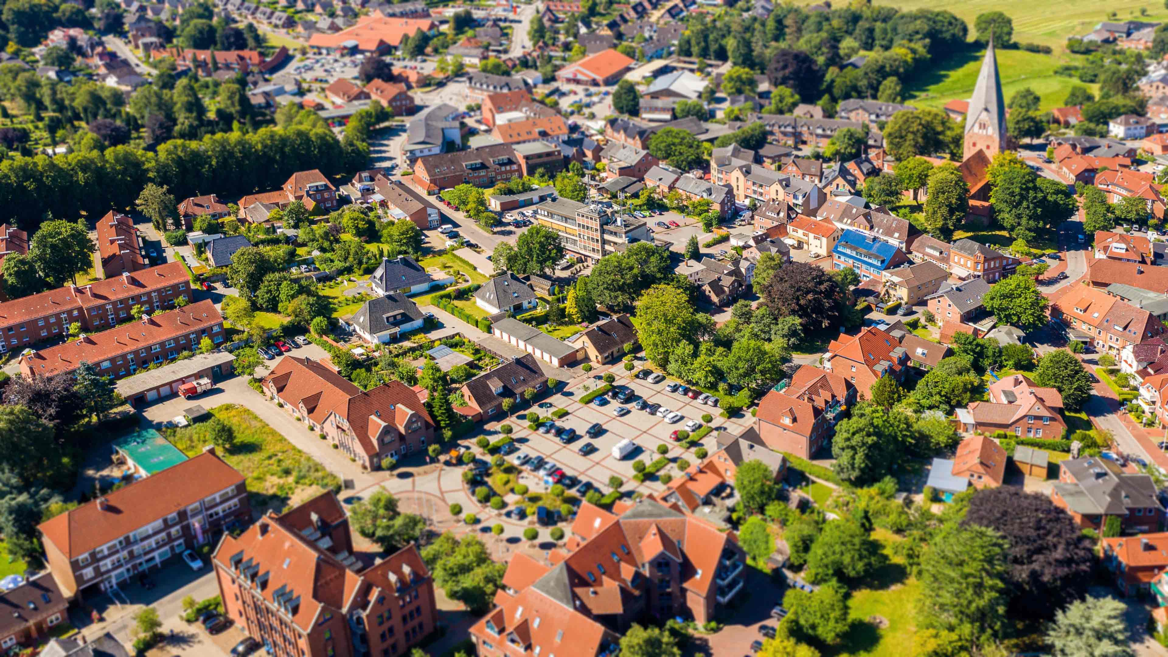 Luftaufnahme von Gettorf mit roten Dächern, Kichturm und Parkplatz