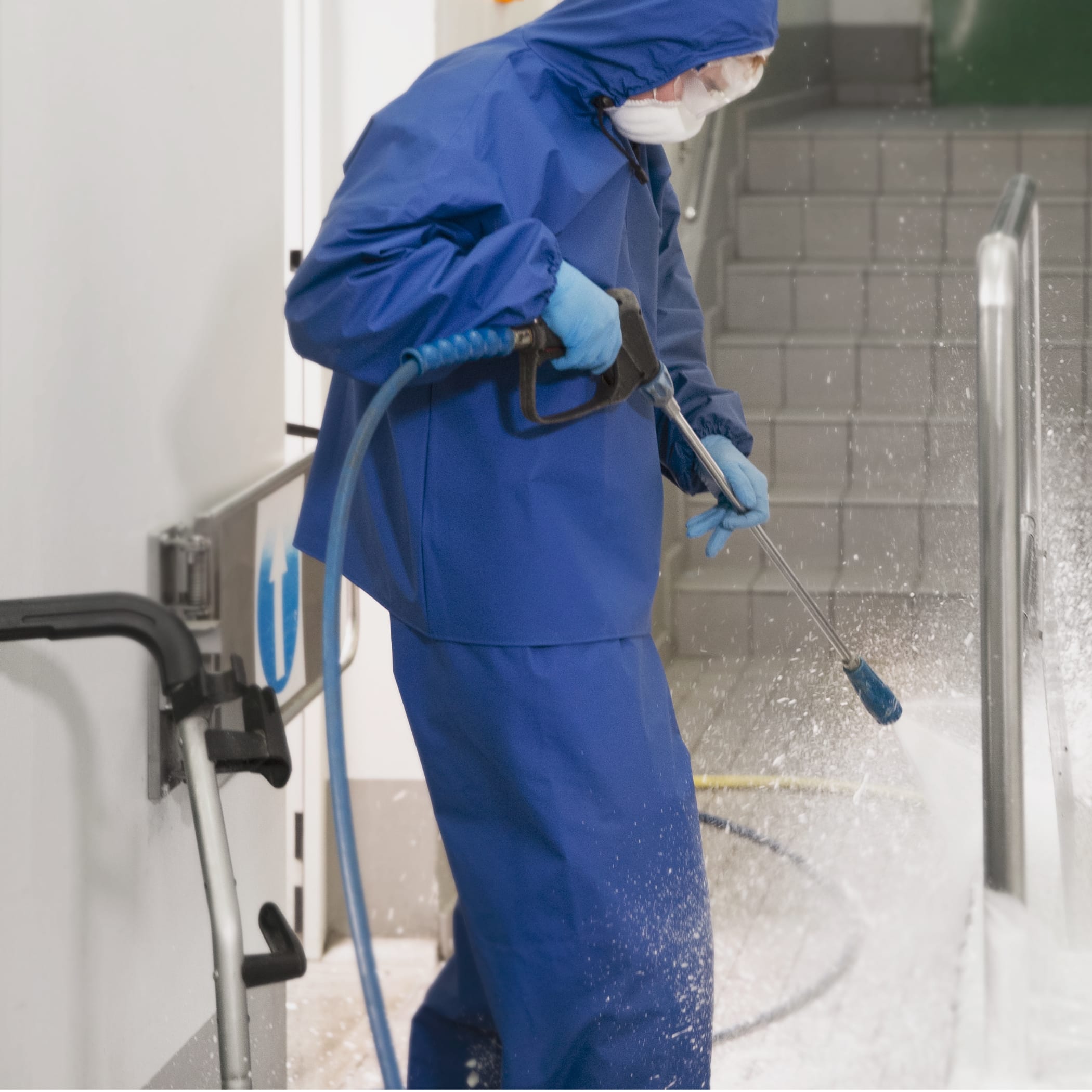 hochzwei_bockh_teaser_01.jpg Person im blauen Ganzkörperanzug sprüht mit Hochdruckreiniger