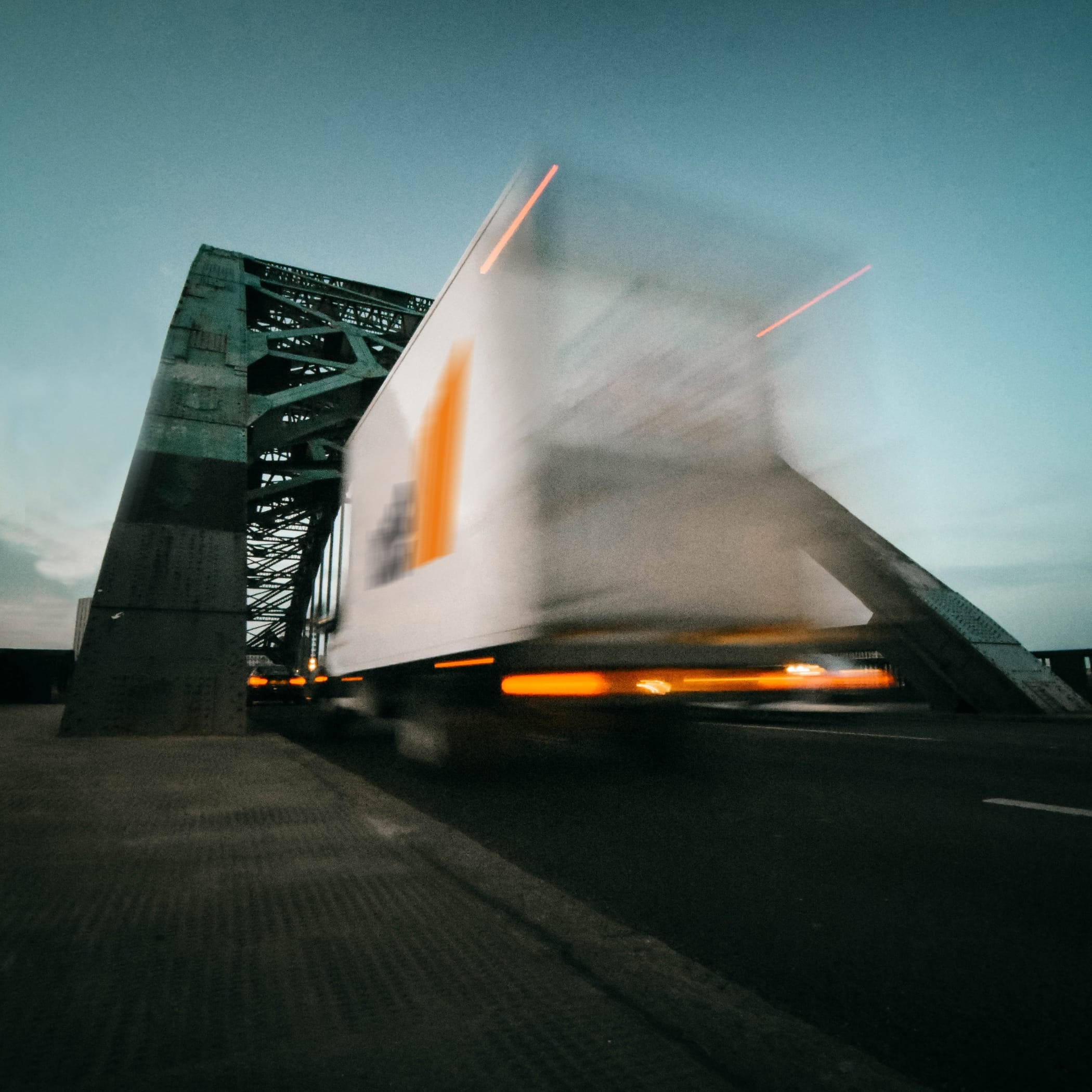 Fahrender weißer LKW unter Brückenkopf