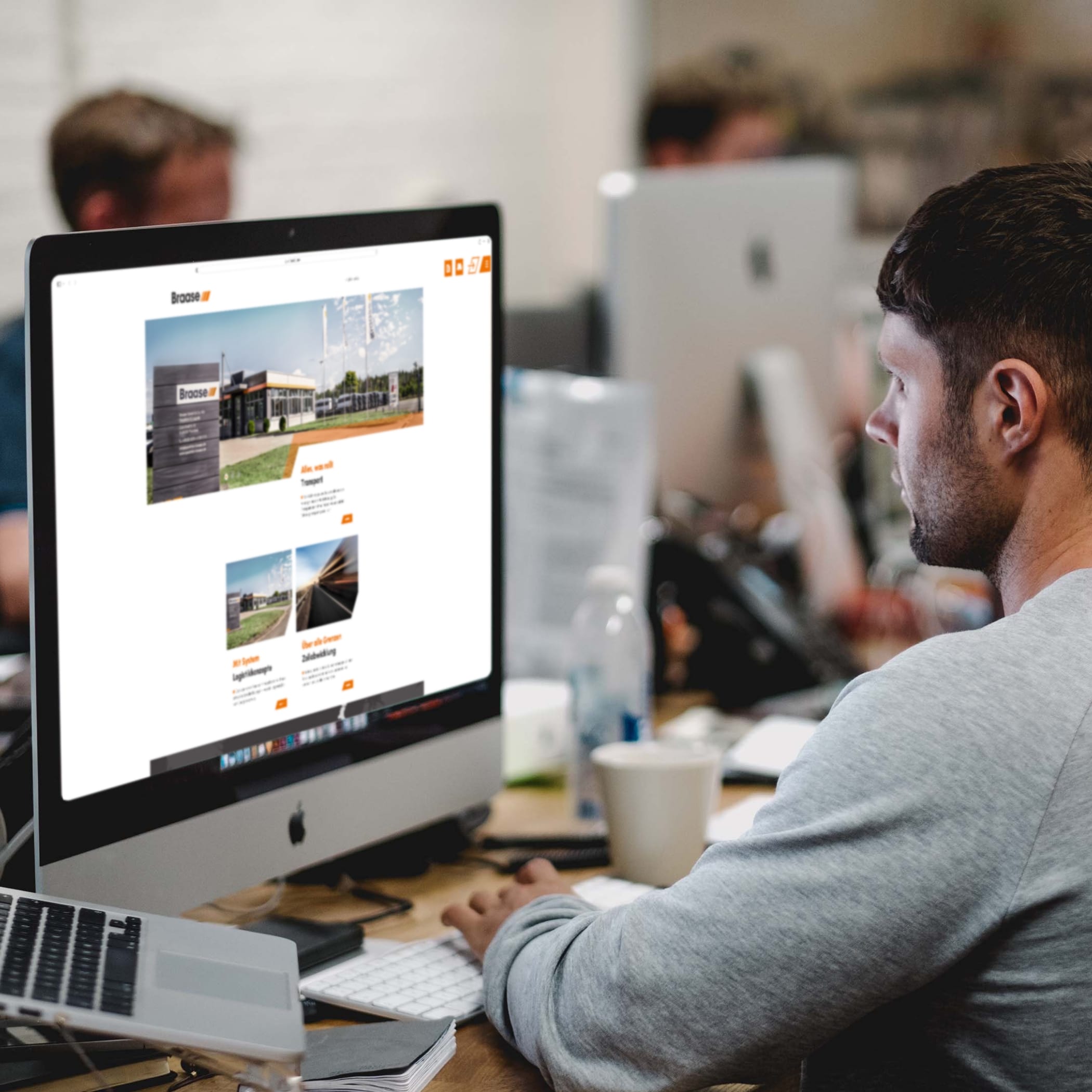 Person am iMac schaut sich Website der Spedition Braase an