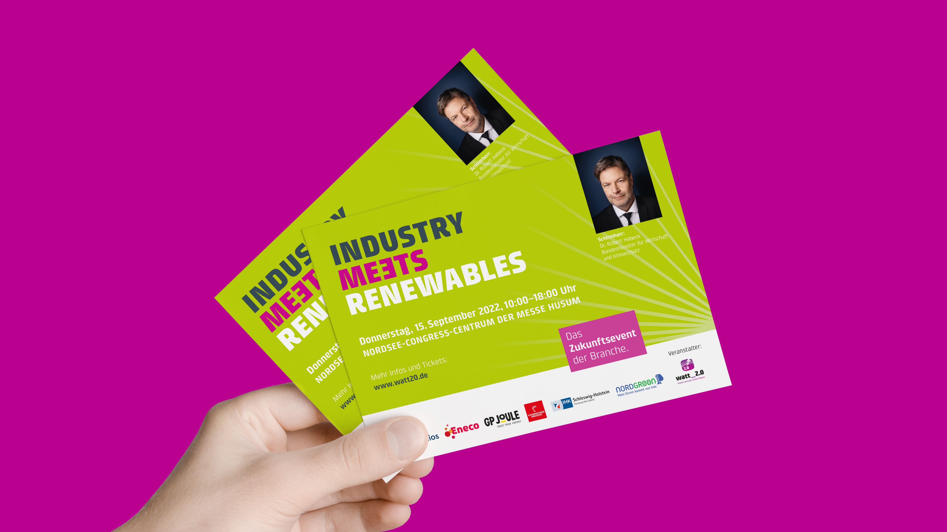 hochzwei_Watt2.0_slider_03.jpg Eine Person hält zwei Flyer von der Watt 2.0 Konferenz in der Hand