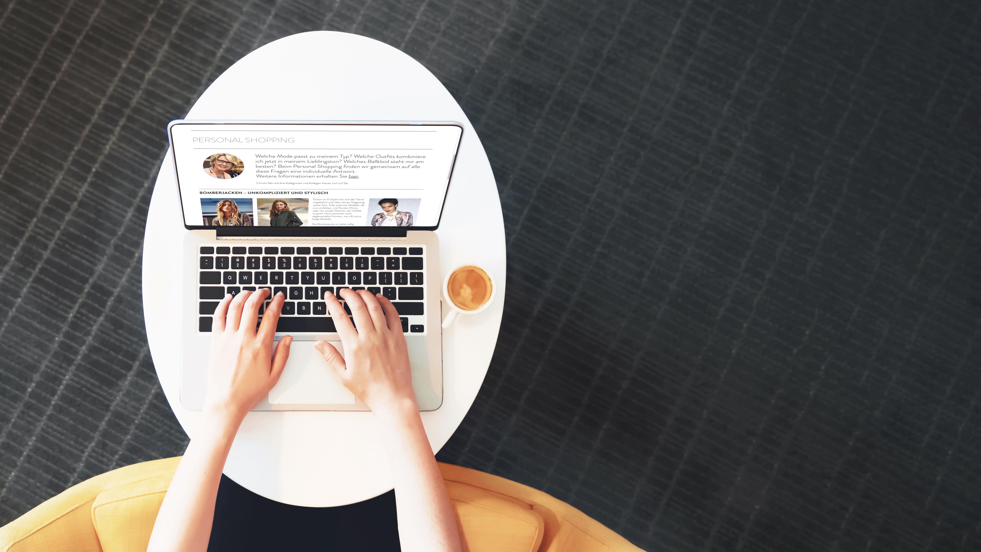 hochzwei_cjsch_slider_03.jpg Draufblick auf einen kleinen Tisch, auf dem ein Laptop steht, der die Website von CJ Schmidt zeigt