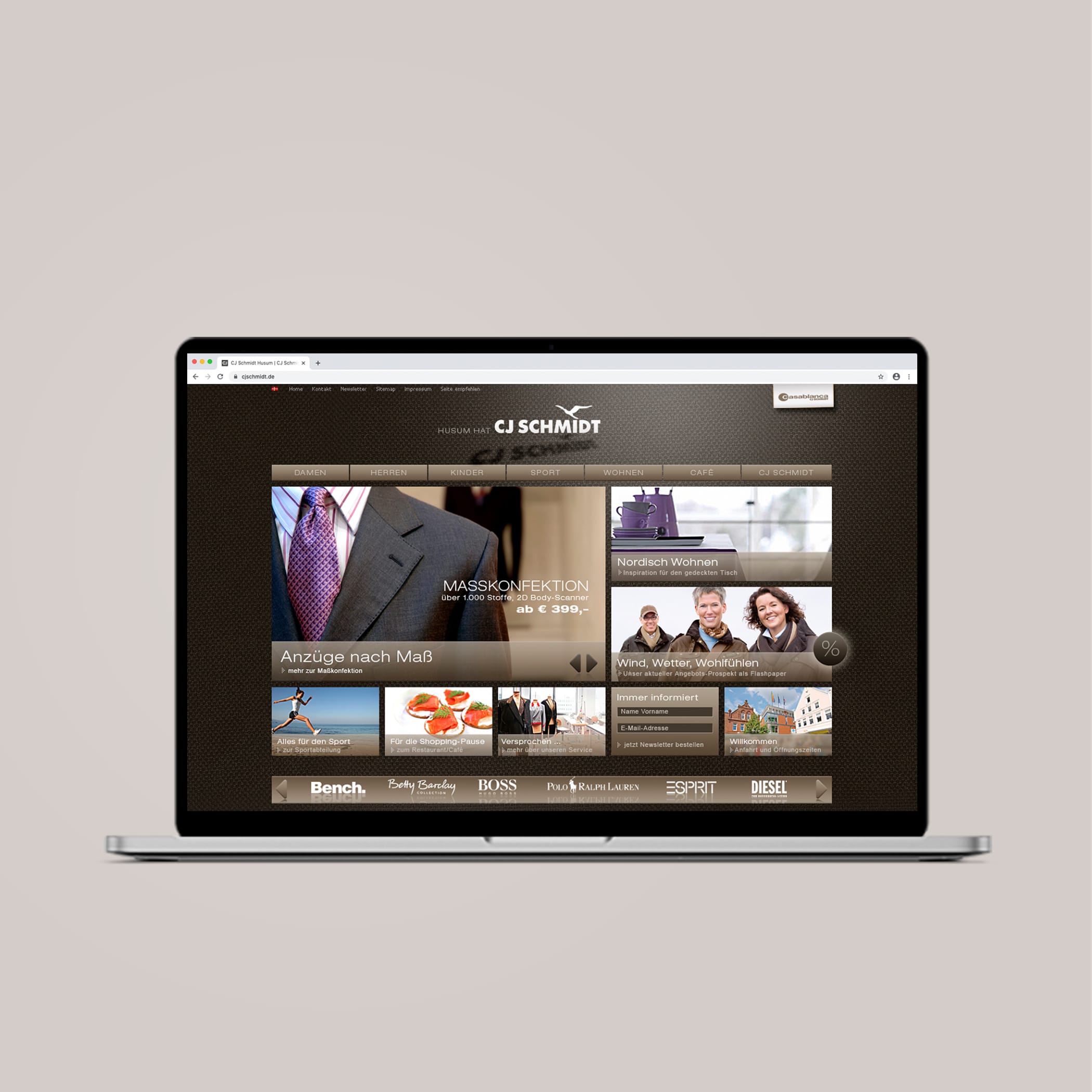 hochzwei_cjsc_teaser_02.jpg Laptop zeigt Website von CJ Schmidt über Anzüge nach Maß