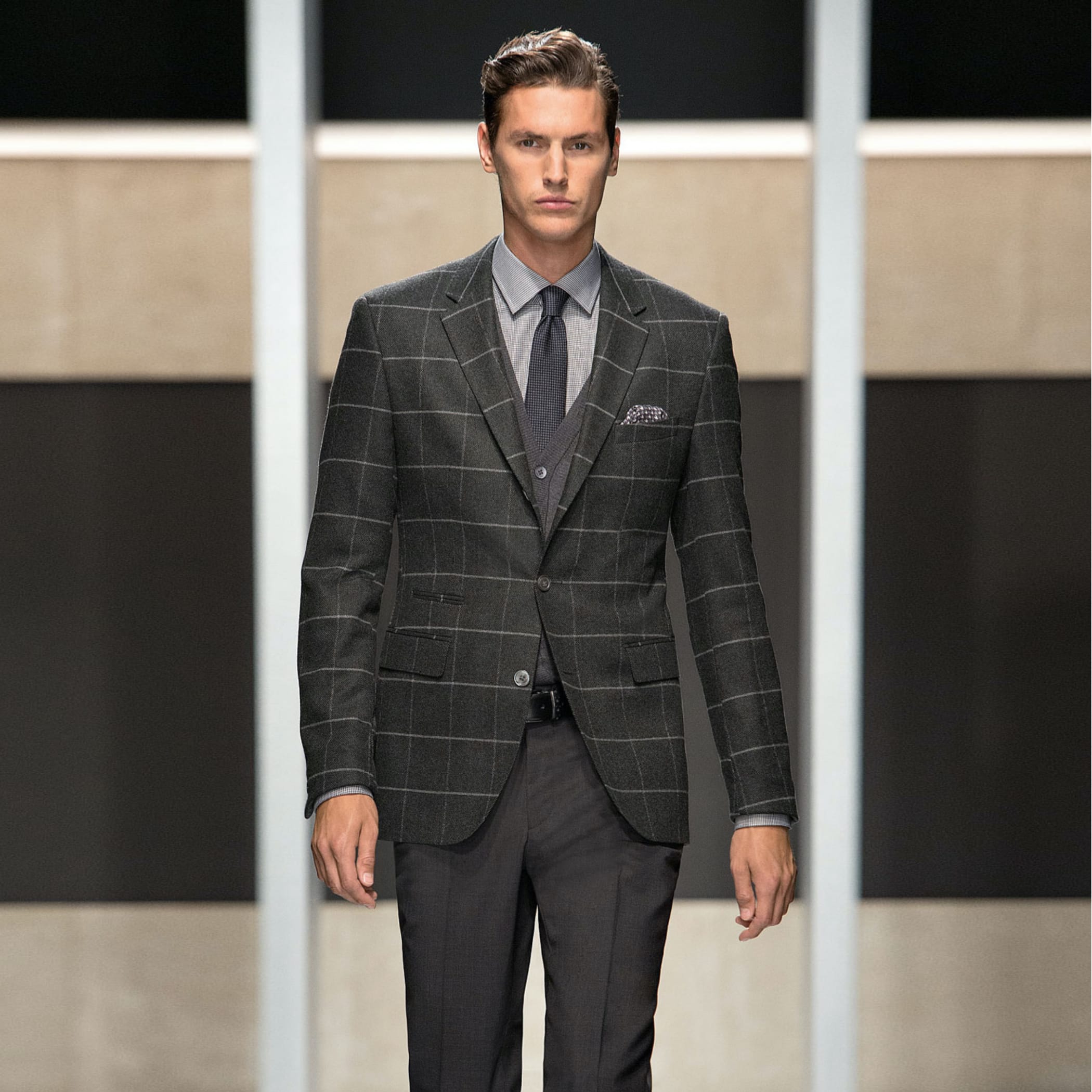 Männliches Model im karierten dunklen Anzug