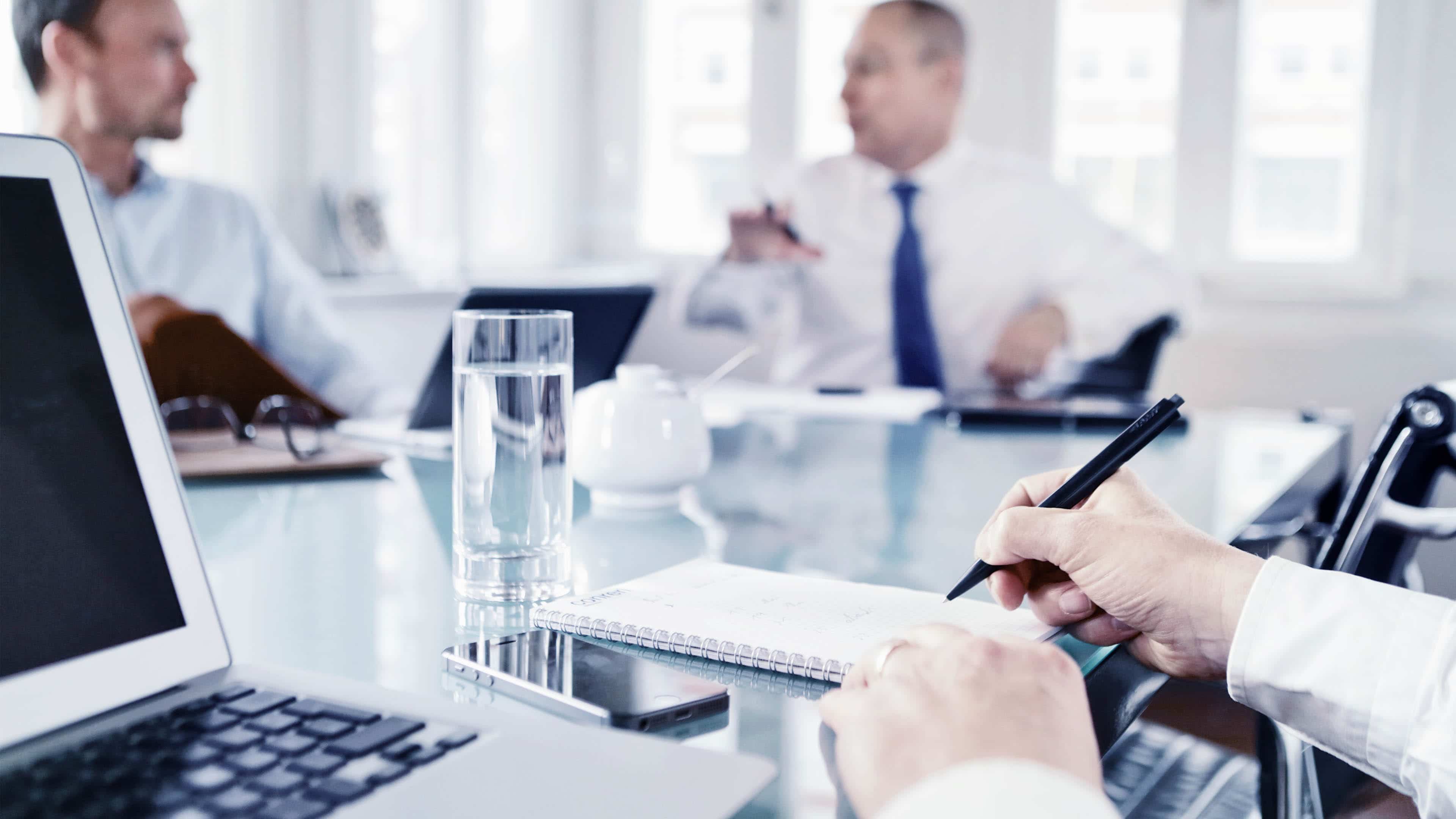 hochzwei_conreri_slider_03.jpg An einem Konferenztisch mit drei Männern