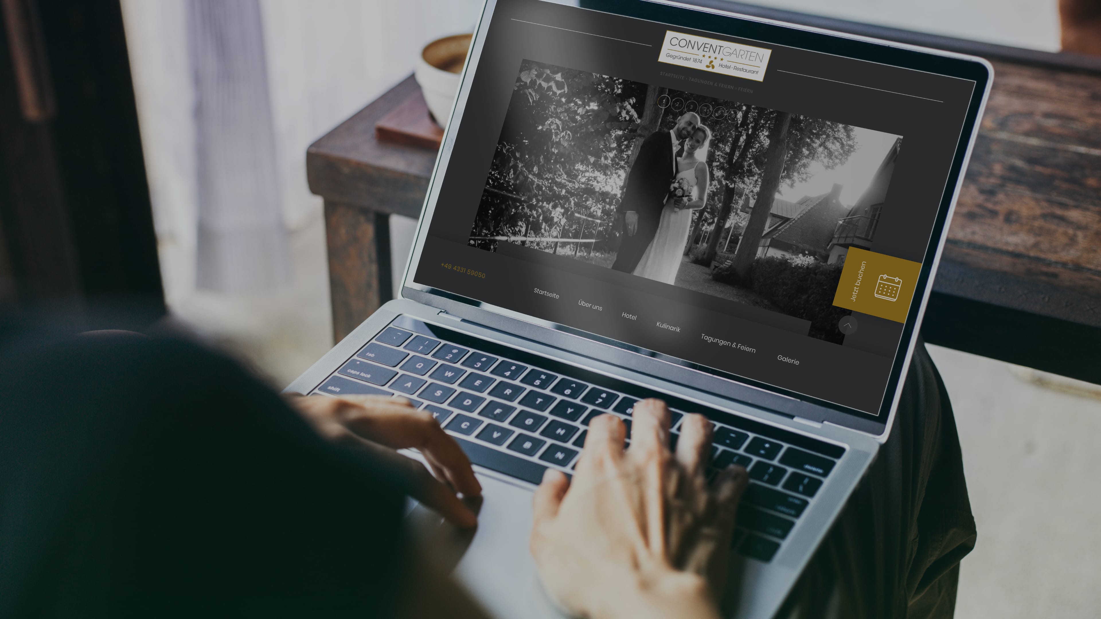 Laptop auf dem Schoß zeigt Website des Hotel Conventgarten und ein Brautpaar