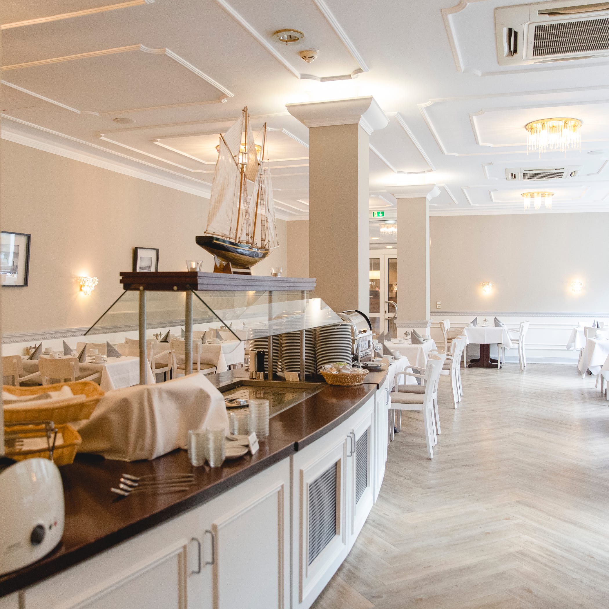 hochzwei_congar_teaser_06.jpg Blick in den leeren aber gedeckten Essens-Buffet-Raum mit Parkett und hohen Decken