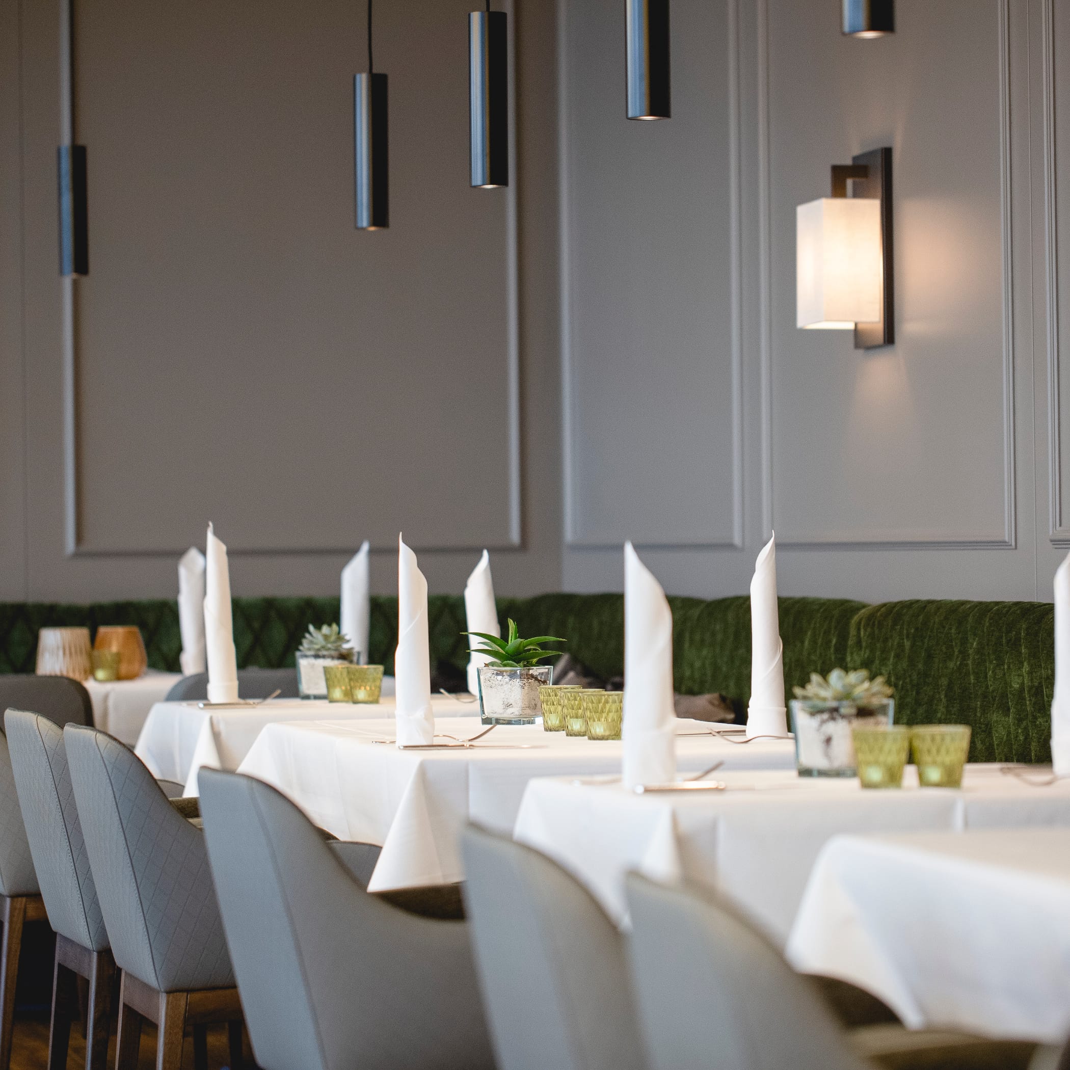 hochzwei_congar_teaser_11.jpg Tische im Conventgarten mit Tischdecken, Servietten vor grauer Wandvertäfelung