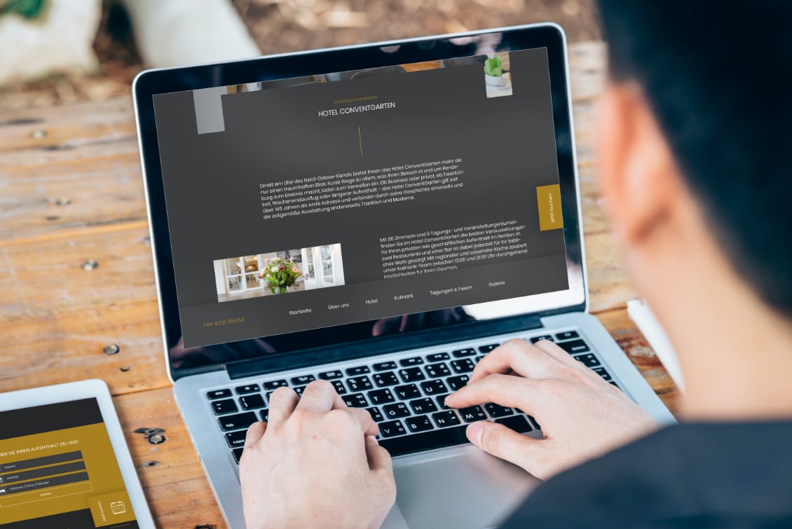 hochzwei_congar_teaser_gross_03.jpg Blick über Schulter eines Mannes, der am Laptop auf Website des Hotel Conventgarten surft