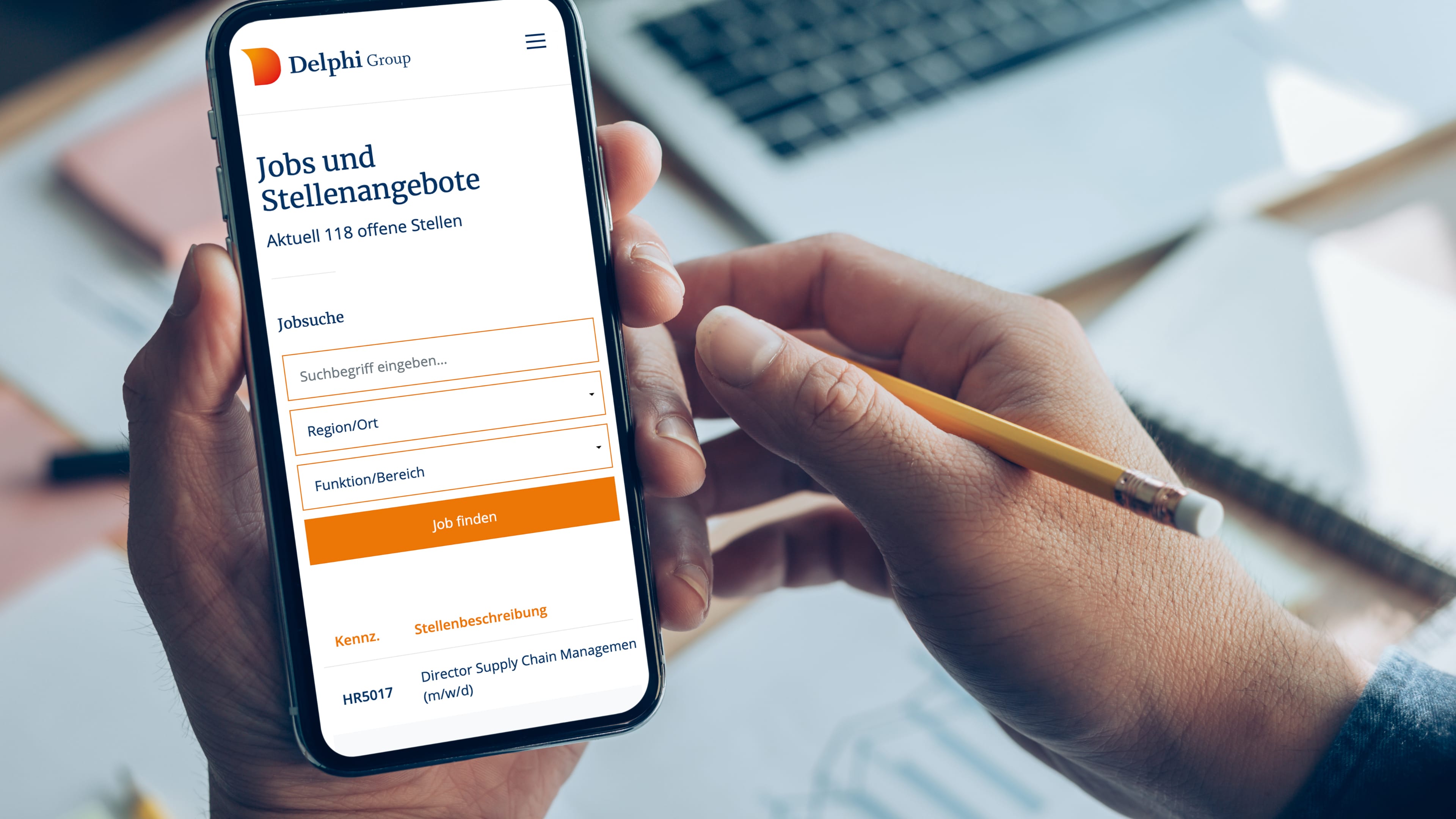 hochzwei_delphi_slider_01.jpg Zwei Hände halten Smartphone, das die Website der Delphi Group zum Thema Jobs zeigt