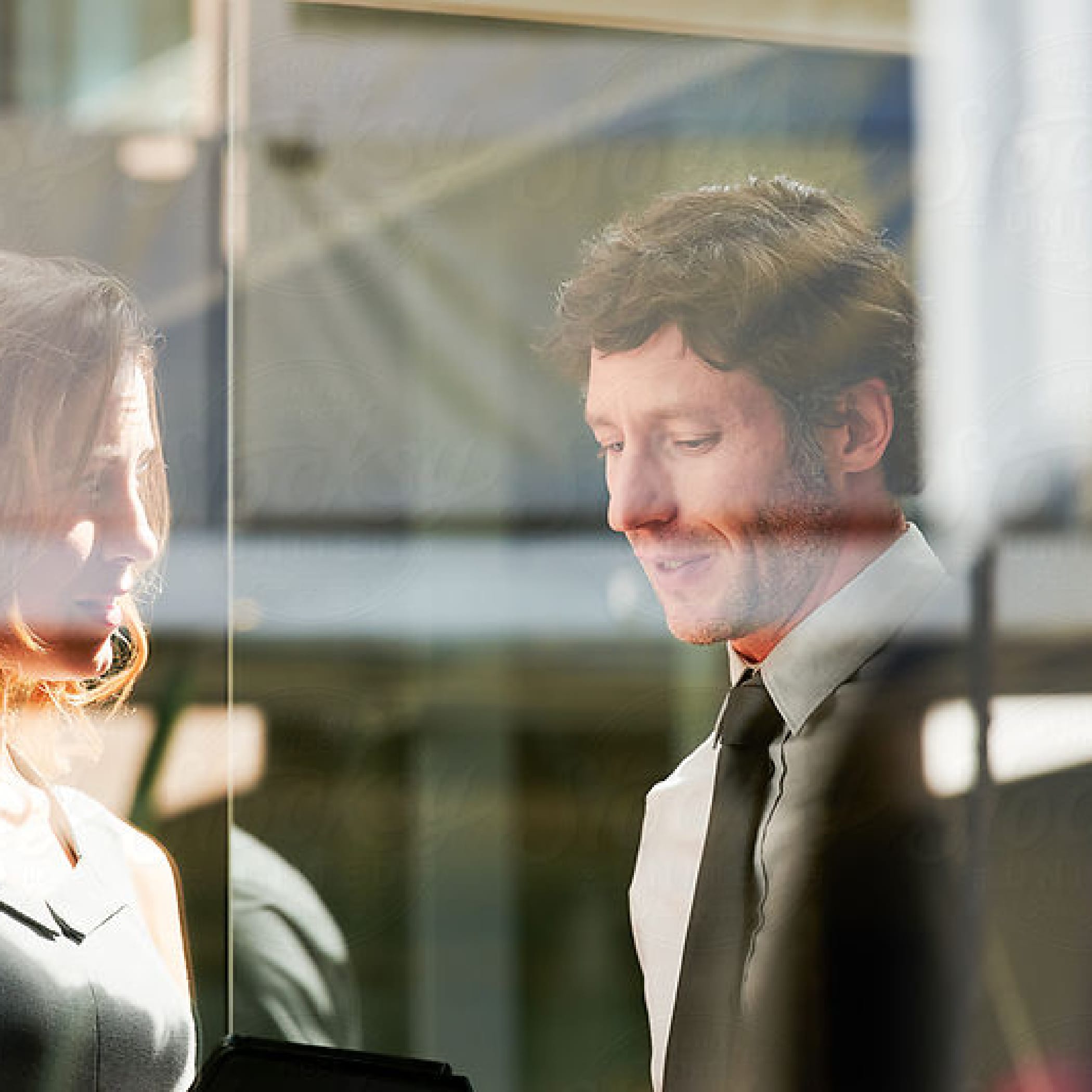 hochzwei_delphi_teaser_02.jpg Blick durch spiegelndes Glas auf einen Mann und eine Frau im Gespräch