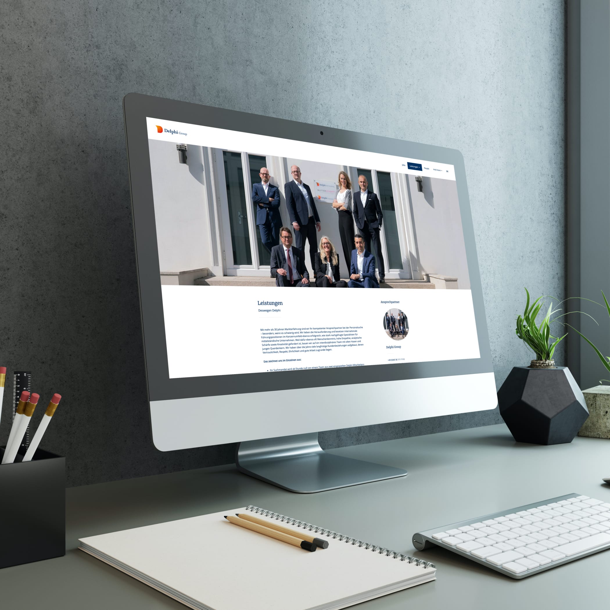hochzwei_delphi_teaser_03.jpg Blick auf einen Arbeitsplatz mit Schreibblock und iMac, der die Website delphi-hr.de zeigt