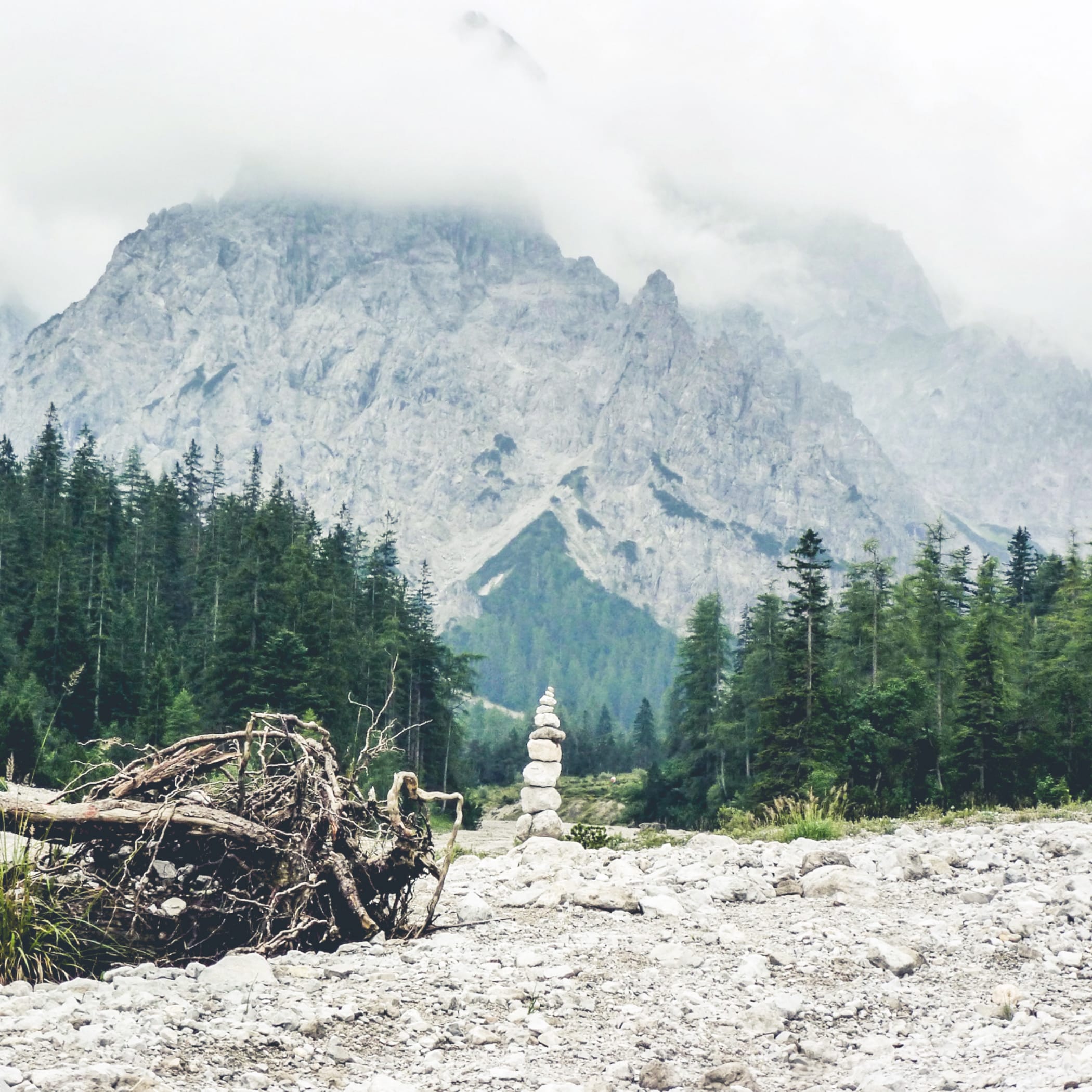 hochzwei_fwschoen_teaser_05.jpg Kleines Türmchen aus Steinen, im Hintergrund ein wolkenverhangener Berg