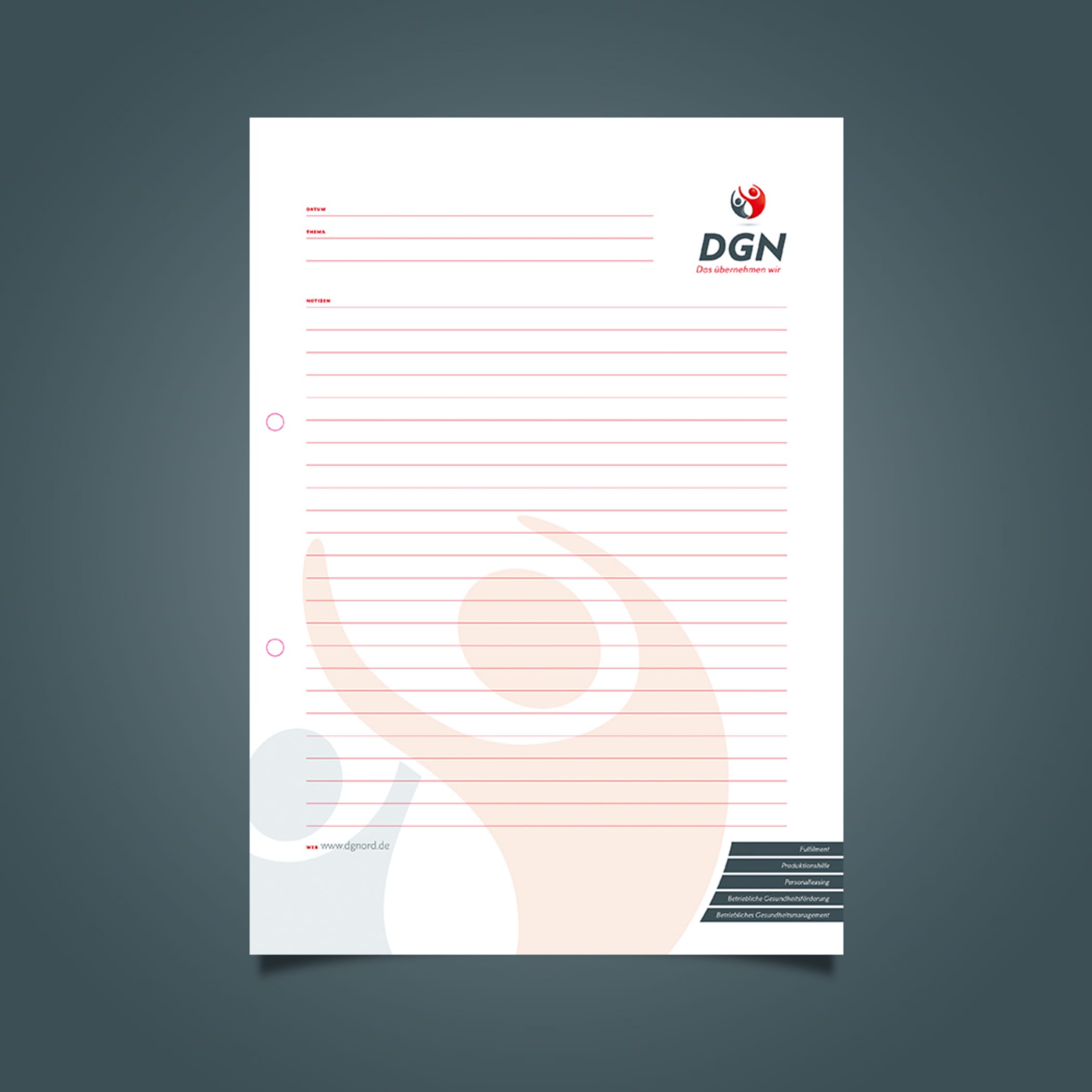 Schreibpapier mit roten Linien und DGN-Logo vor grauem Hintergrund