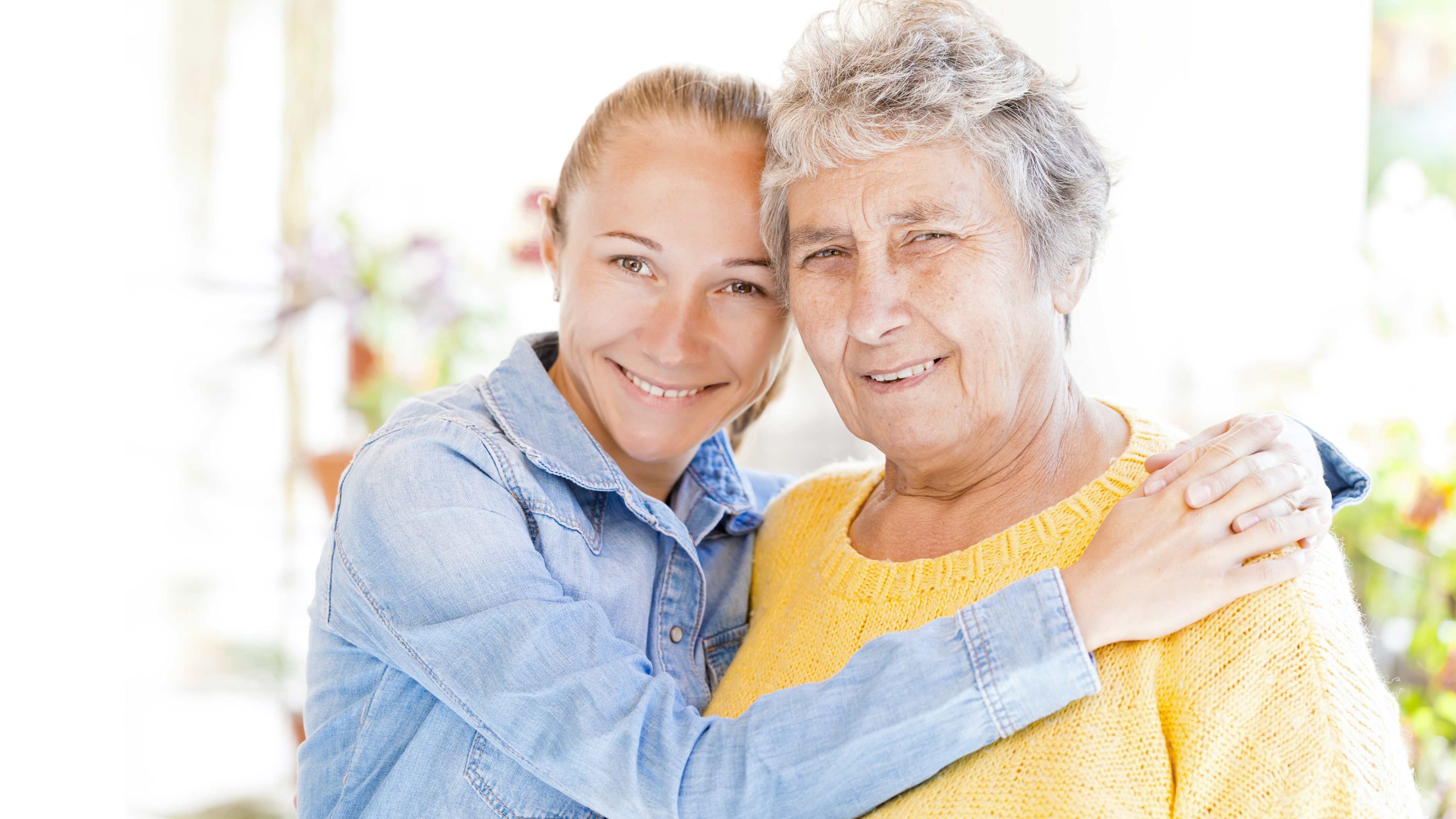hochzwei_dpfl_slider_03.jpg Junge und alte Frau halten sich in die Kamera blicken im Arm